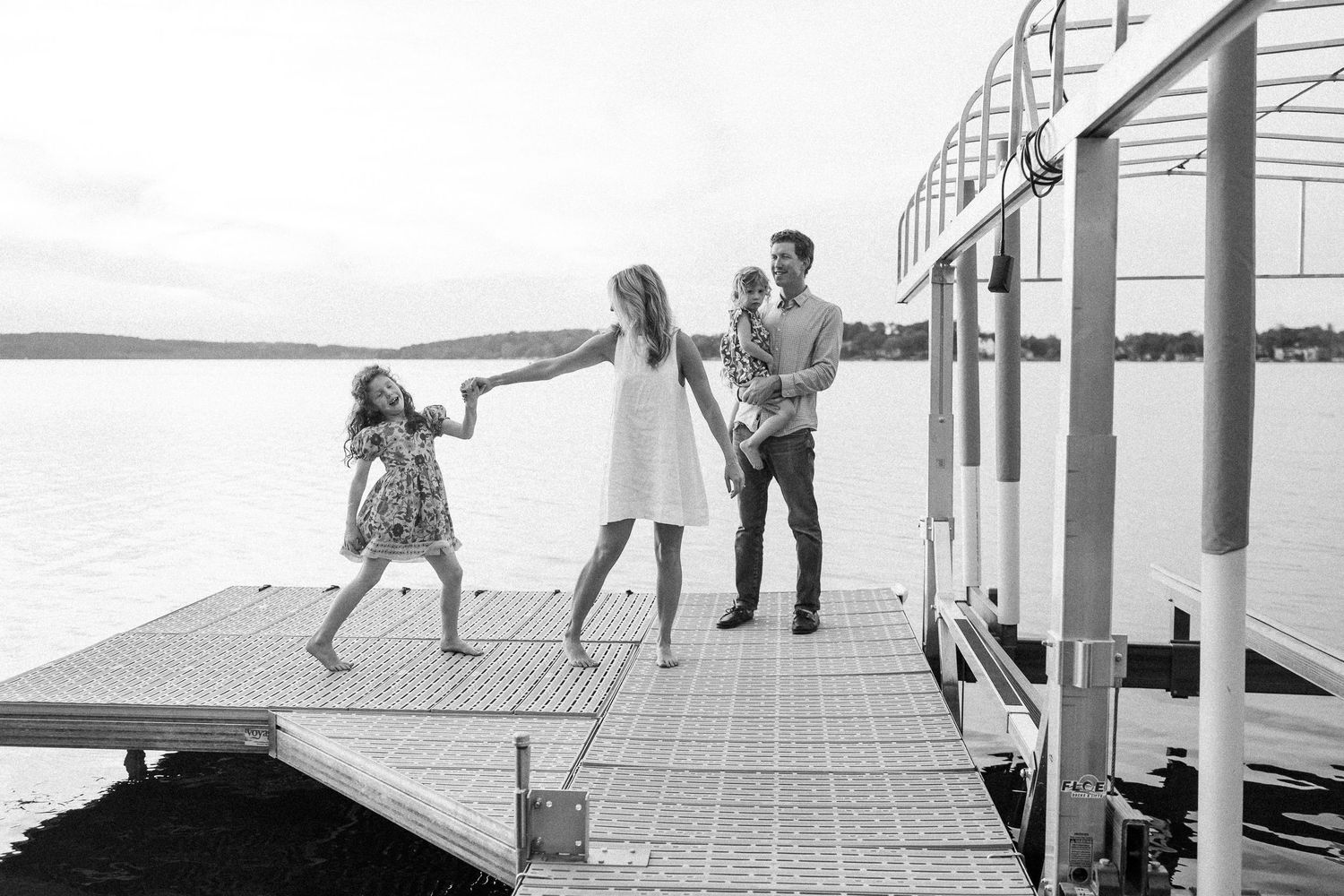 A sequence of black and white photographs shows people playing and interacting on a dock or pier by the water.