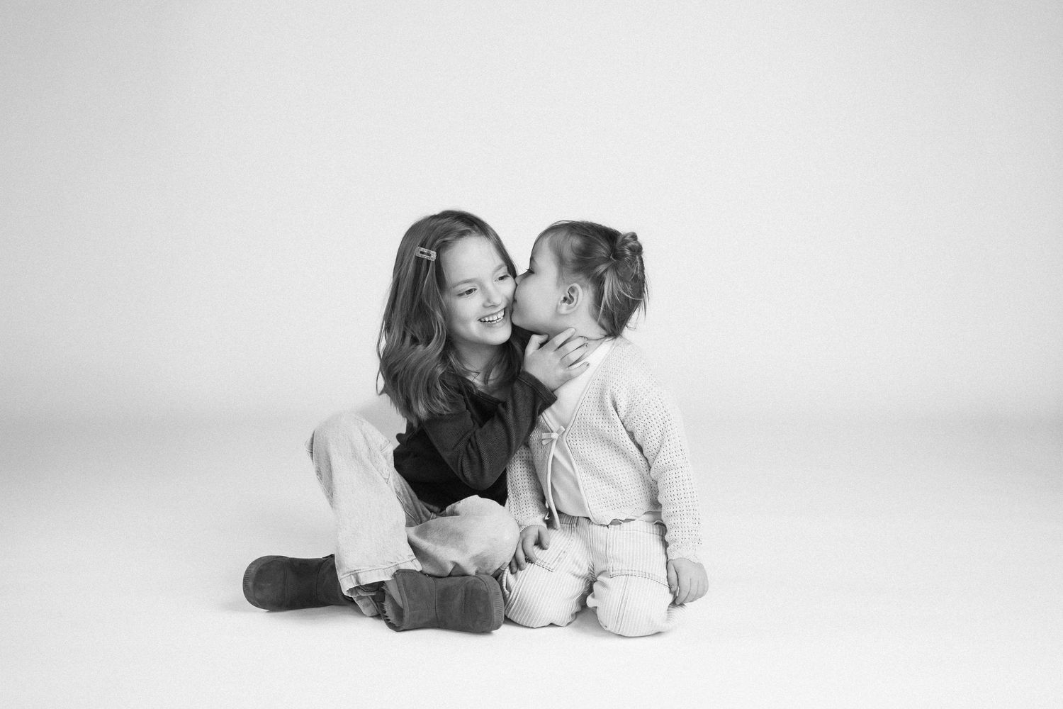A series of black and white photographs showing tender moments between parent and child lying down together.