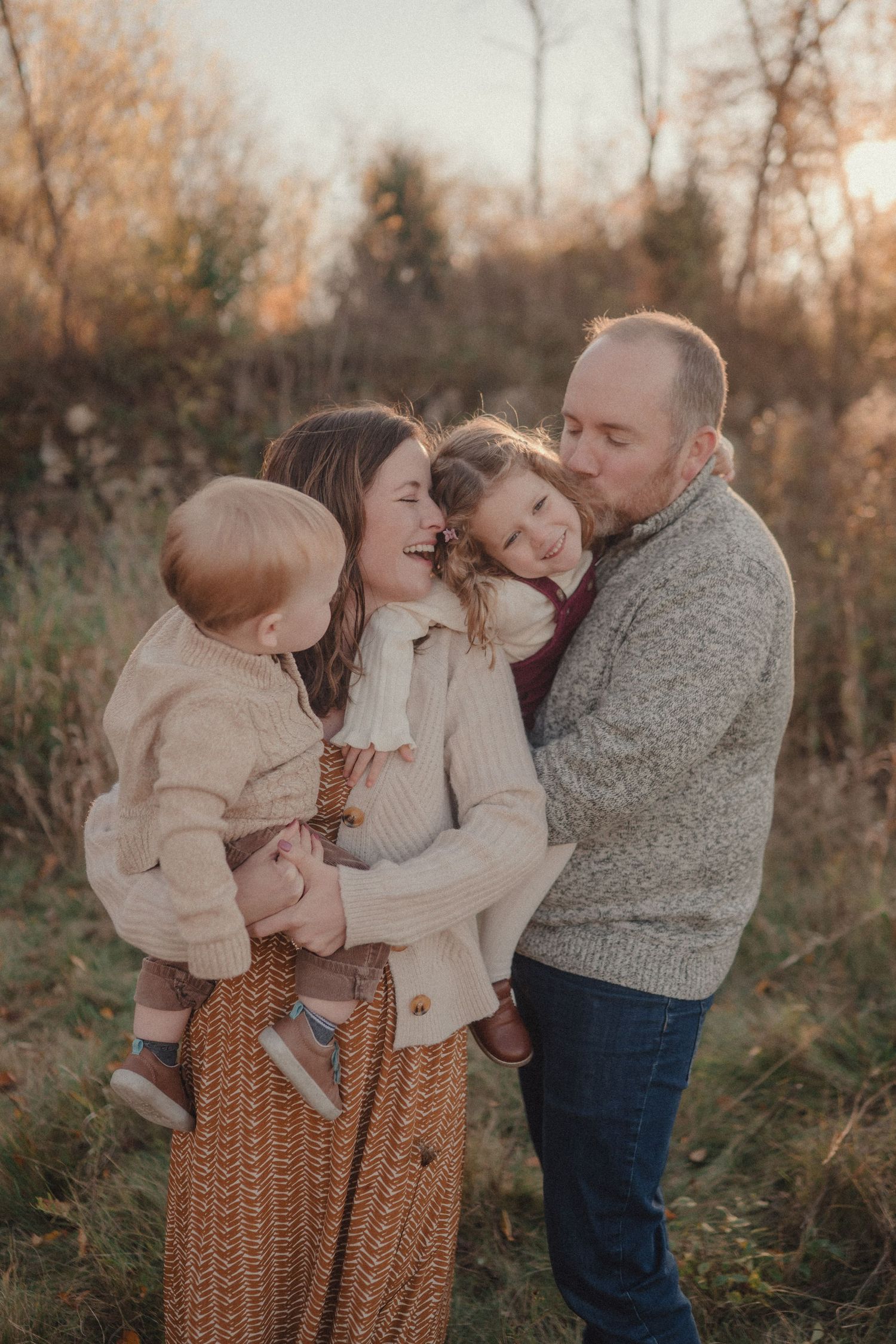 Candid family interactions during sunset photoshoot in tall autumn grass.