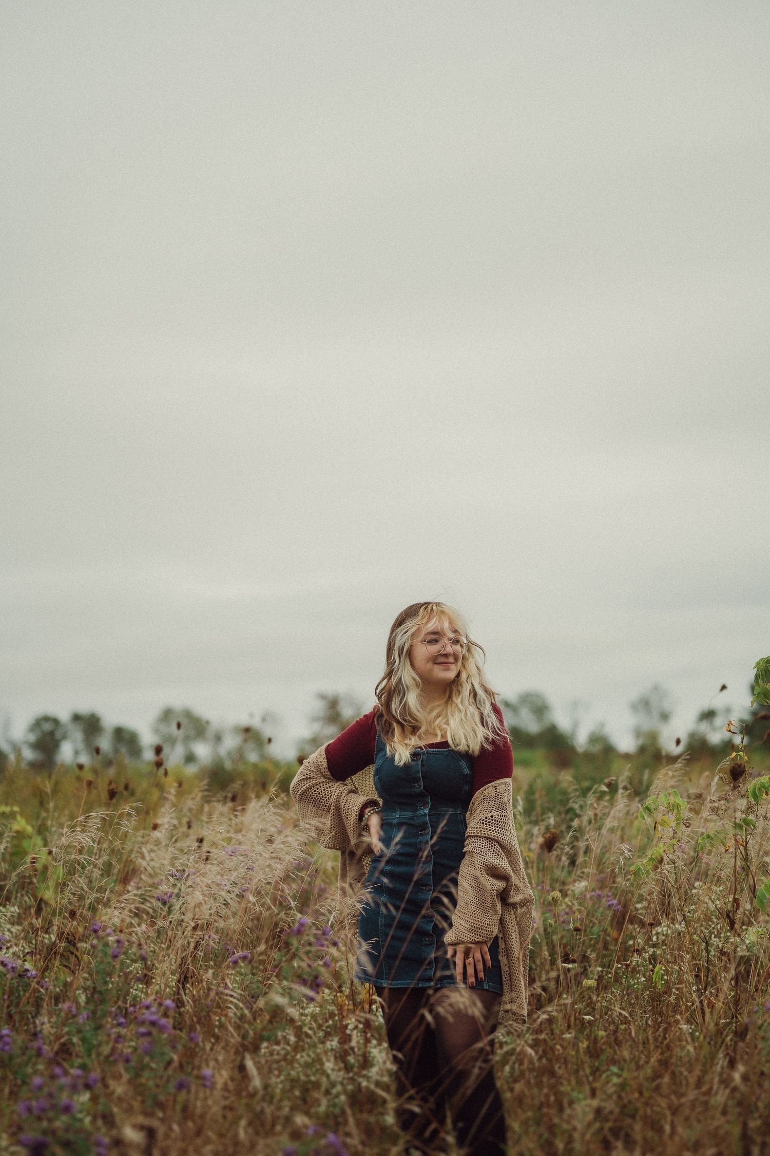Carefree moment captured in autumn wildflower field under cloudy sky.