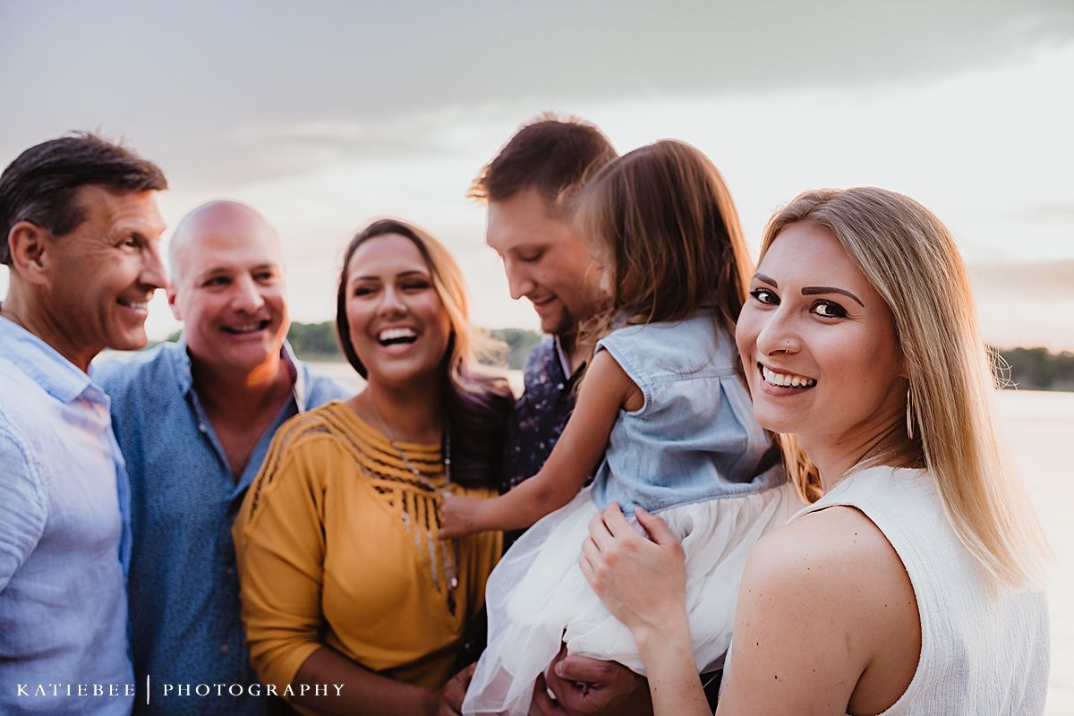 A happy group gathering with laughter during sunset by the water.