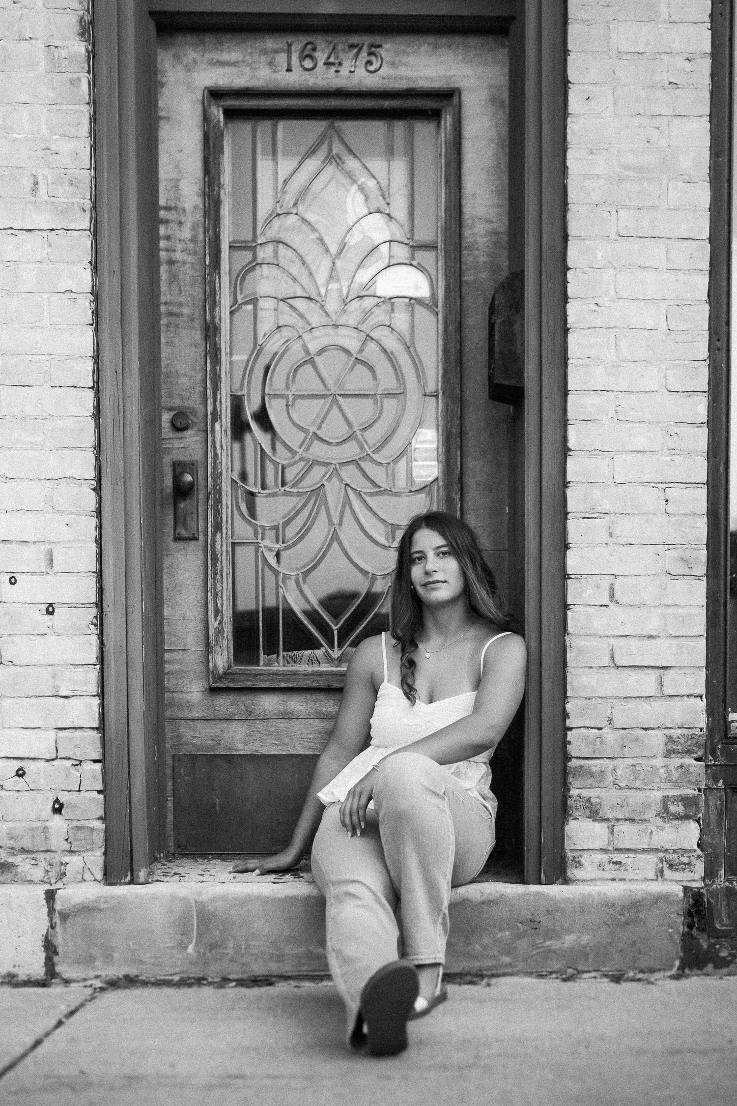 A black and white architectural photo featuring ornate doorways and brick walls.