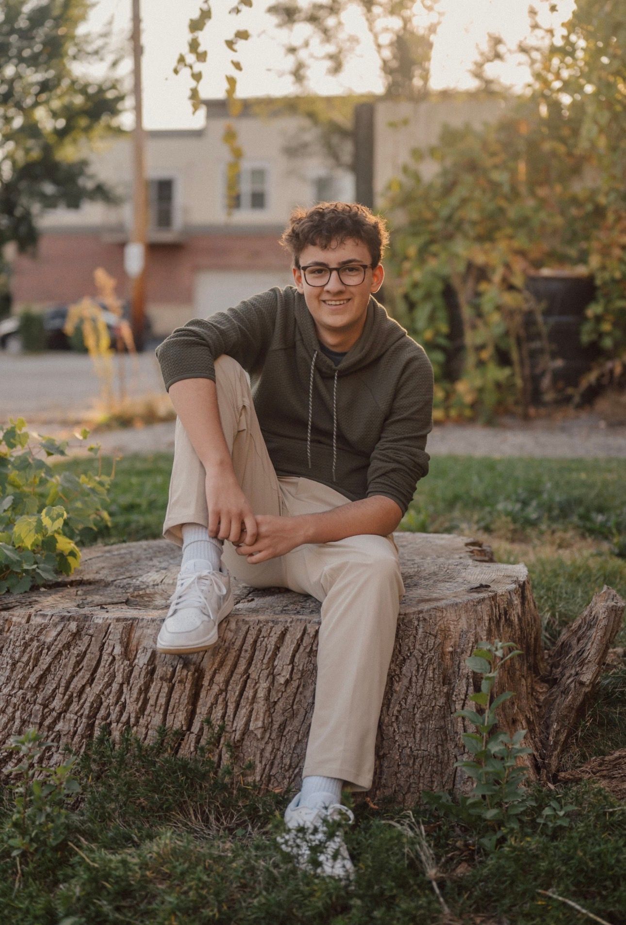 Casual portrait on rustic tree stump in autumn garden setting.