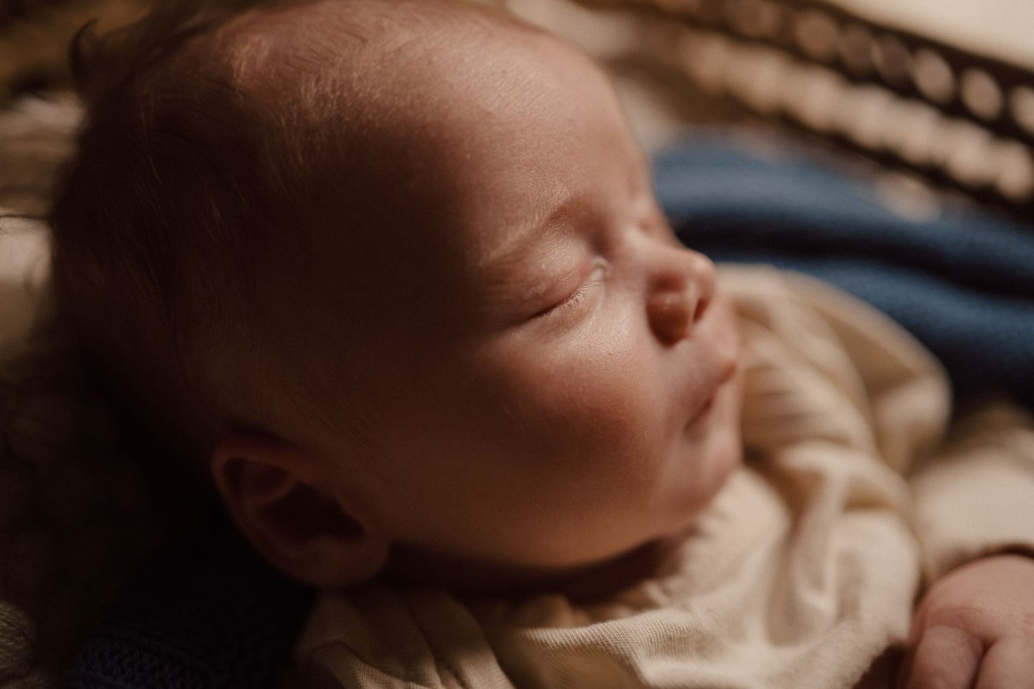 Close-up portrait of a peaceful sleeping baby in soft lighting.