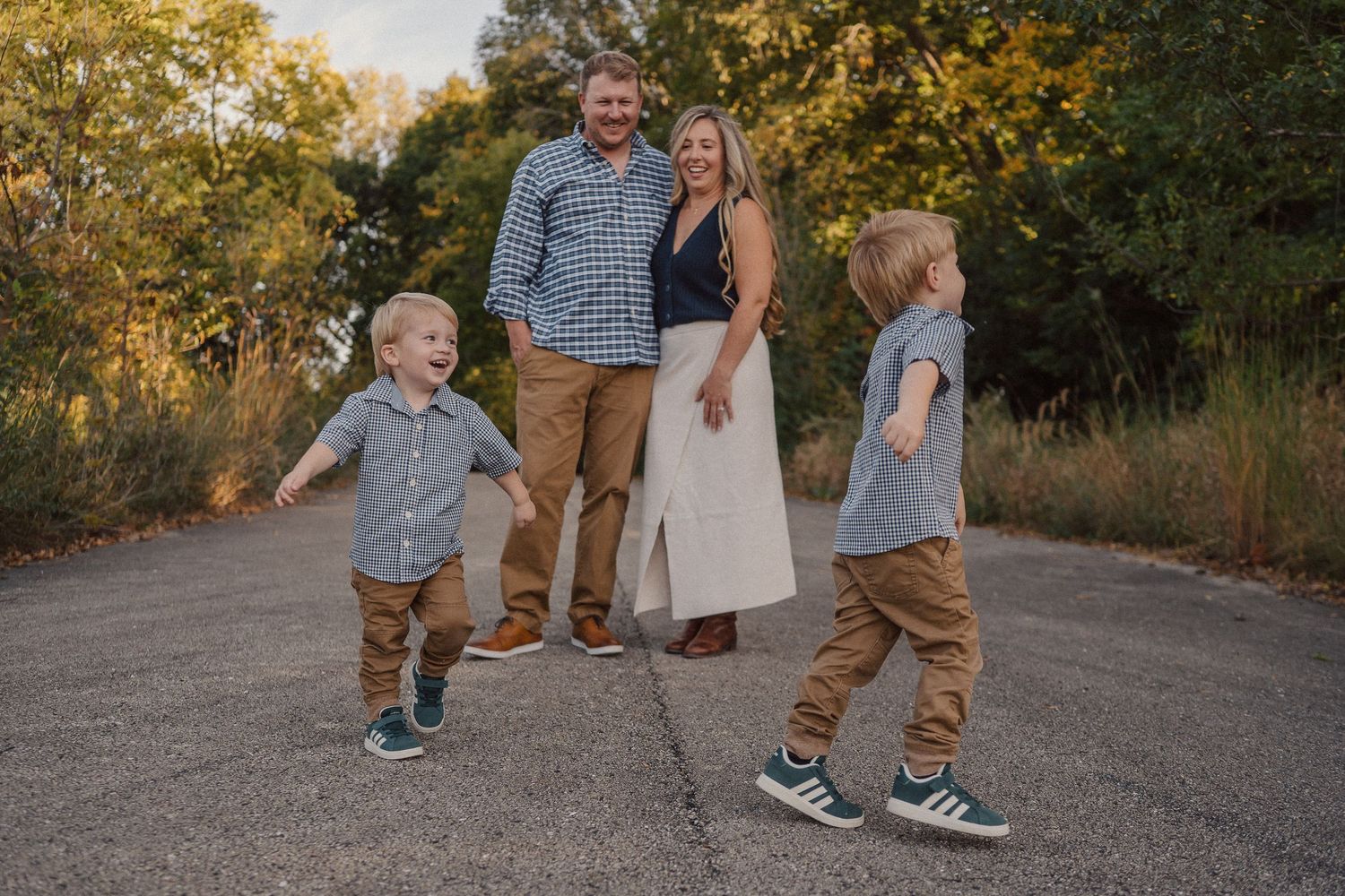 Family members walking together on a gravel path during sunset.