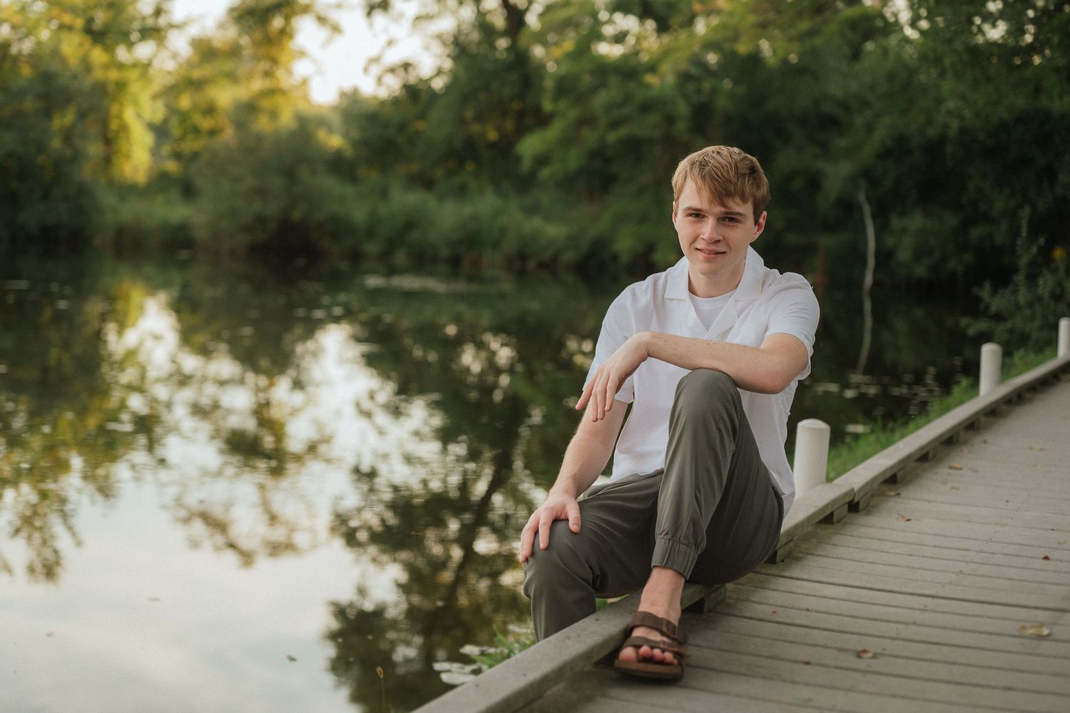 Wooden boardwalk stretches across tranquil water during golden hour.
