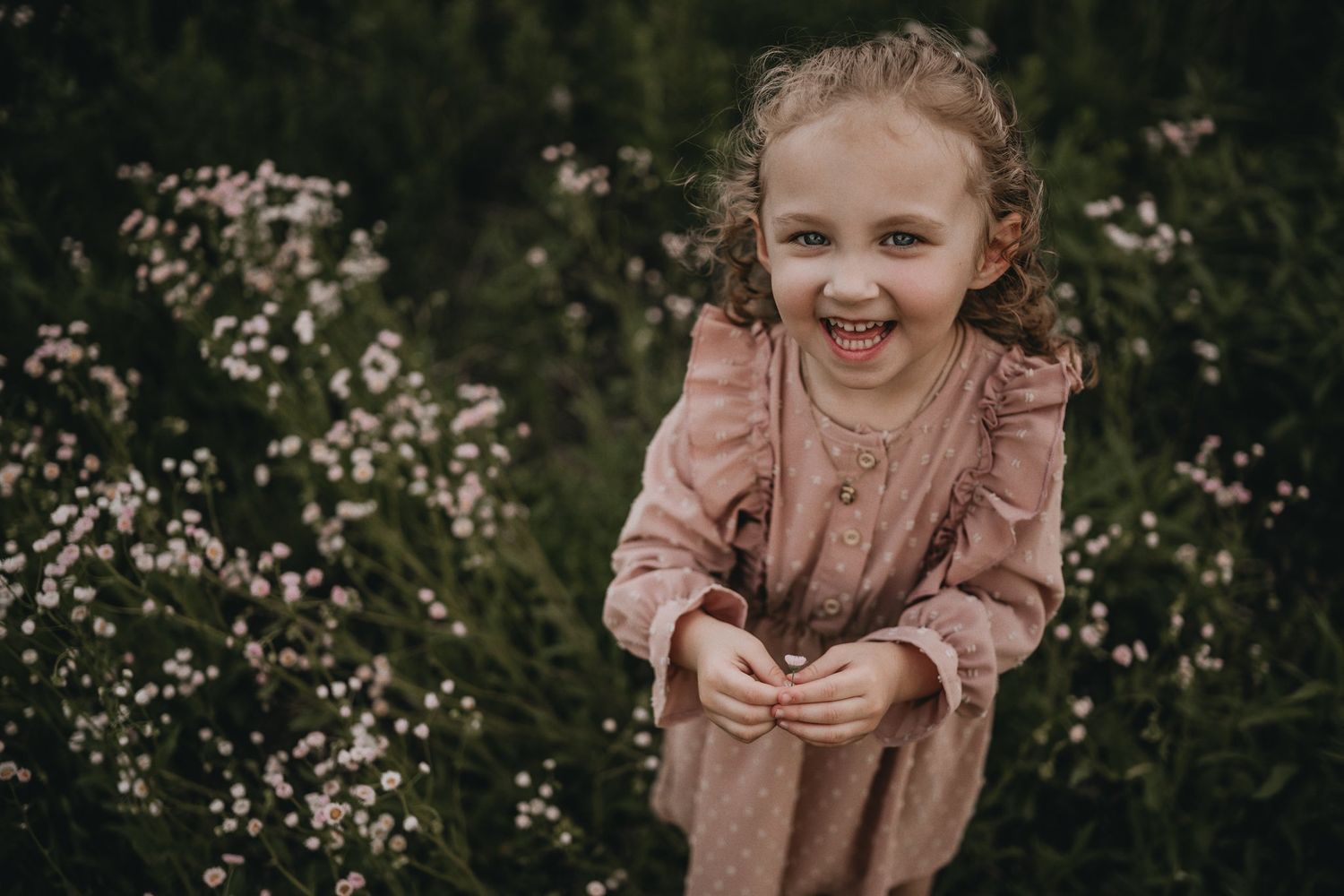 Candid moment of laughter while playing in a wildflower field.