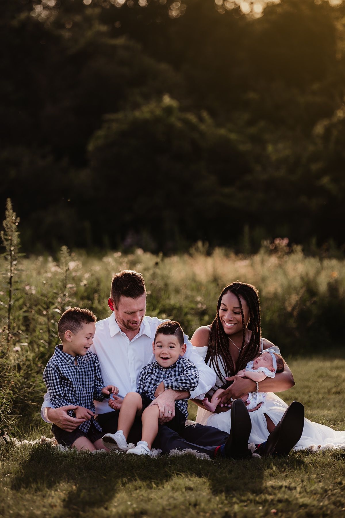 Sunset family portrait in a meadow with wildflowers and golden light.