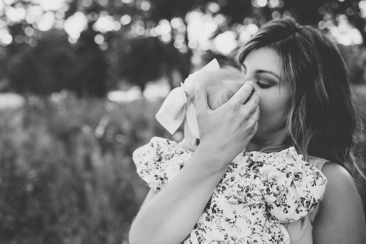 Black and white photo of tender moment between parent and baby.