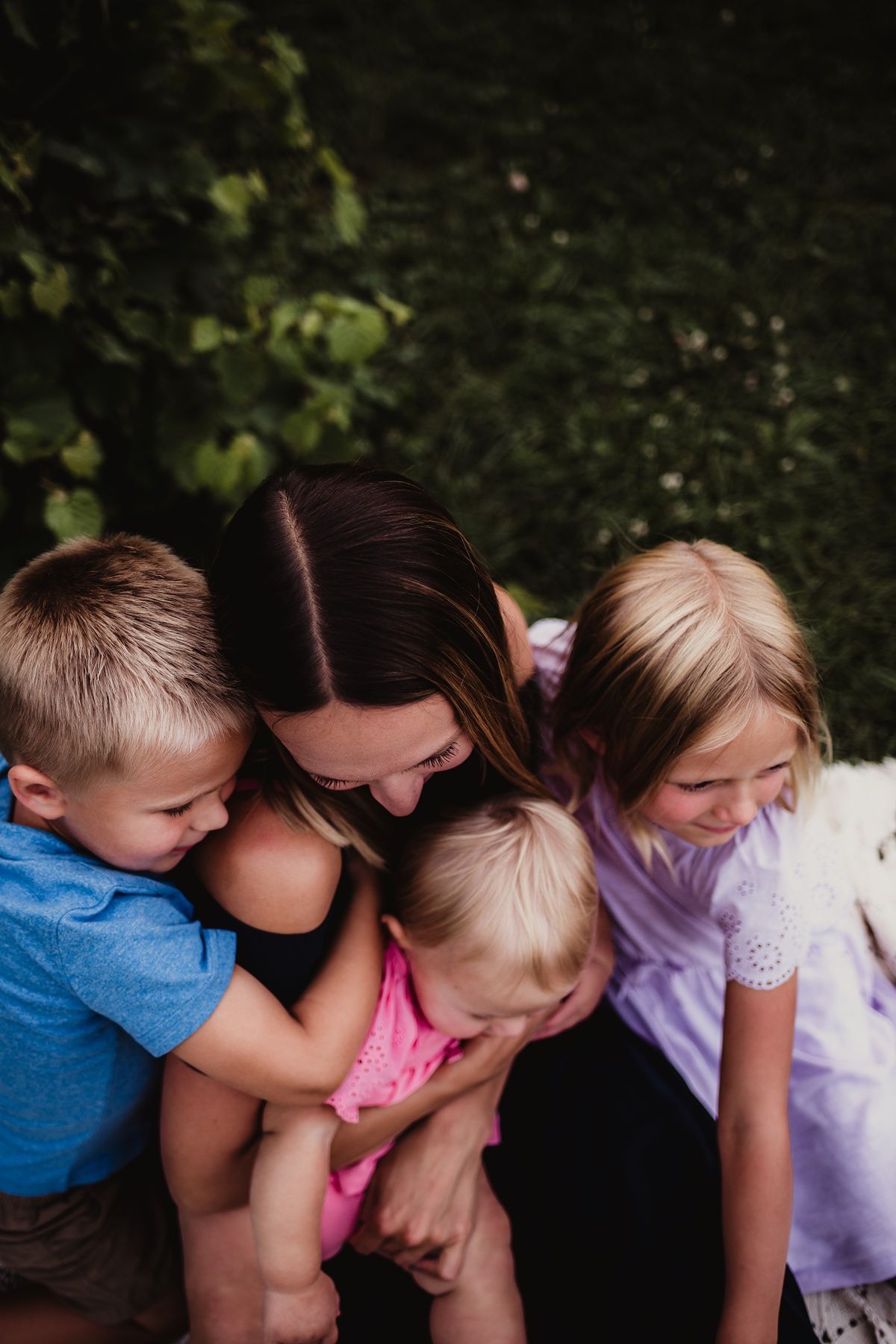 Close group huddle of family members sharing an intimate moment outdoors.