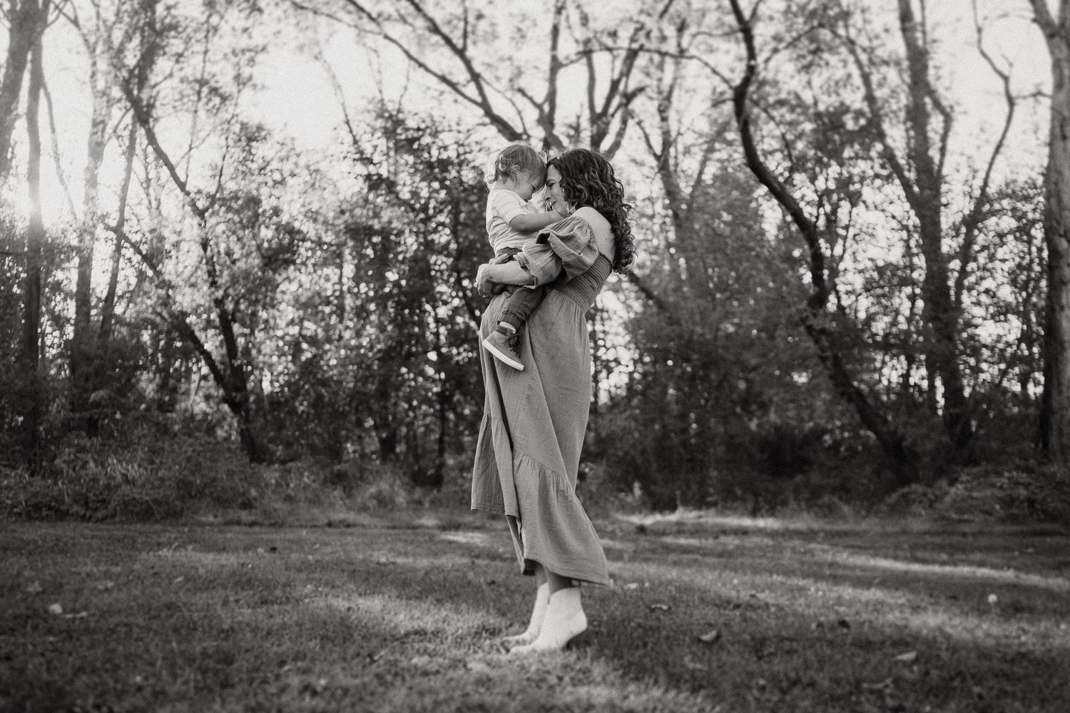 Black and white photo capturing a tender moment outdoors.