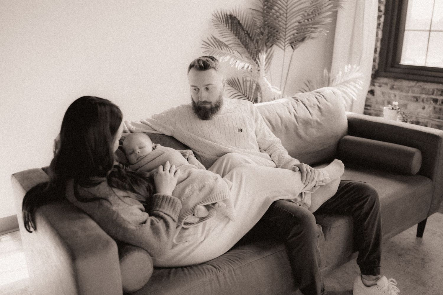 Lifestyle photography session on a couch capturing candid intimate moments in black and white.
