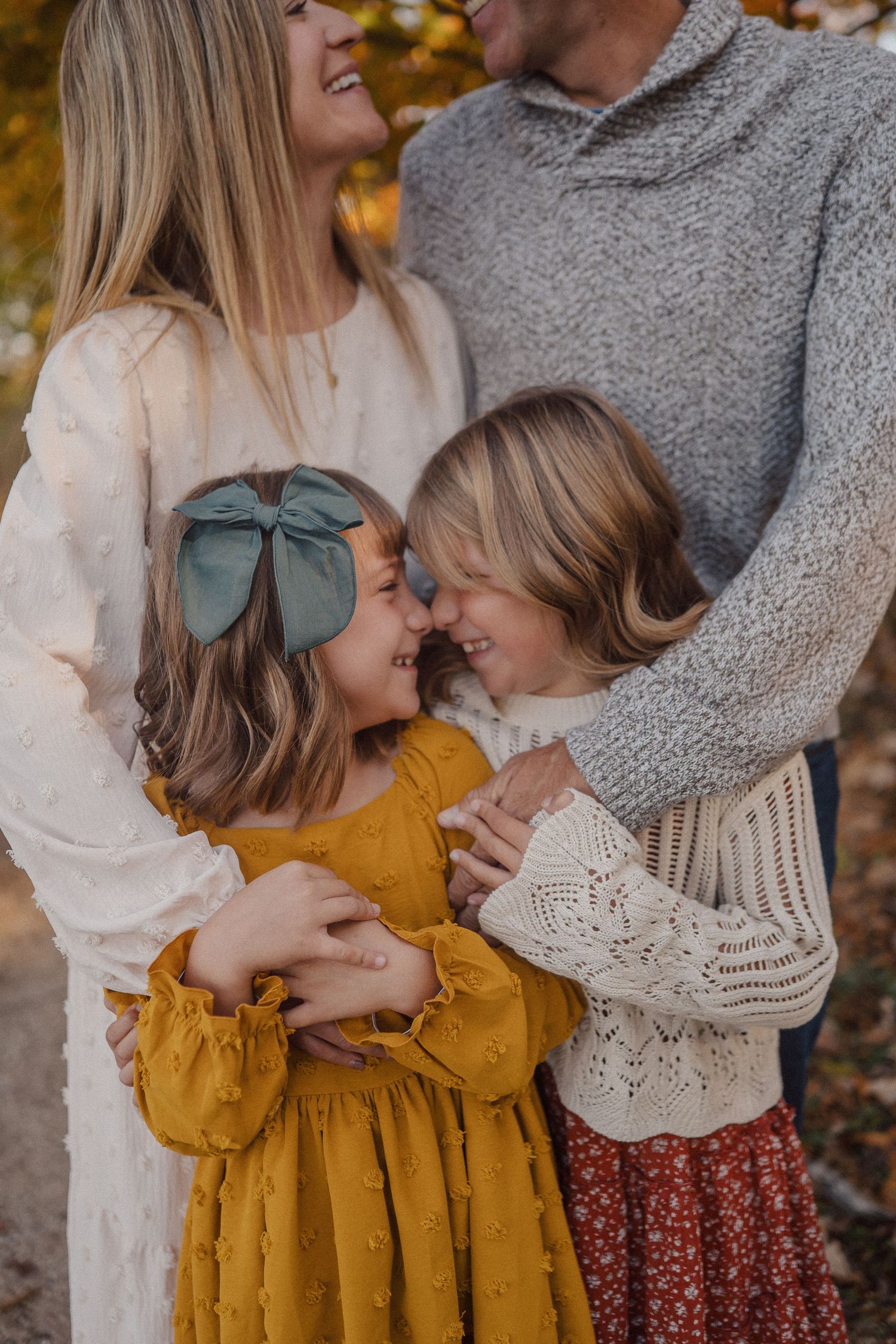 A loving family shares a tender moment together outdoors during autumn, wearing cozy sweaters and seasonal attire.