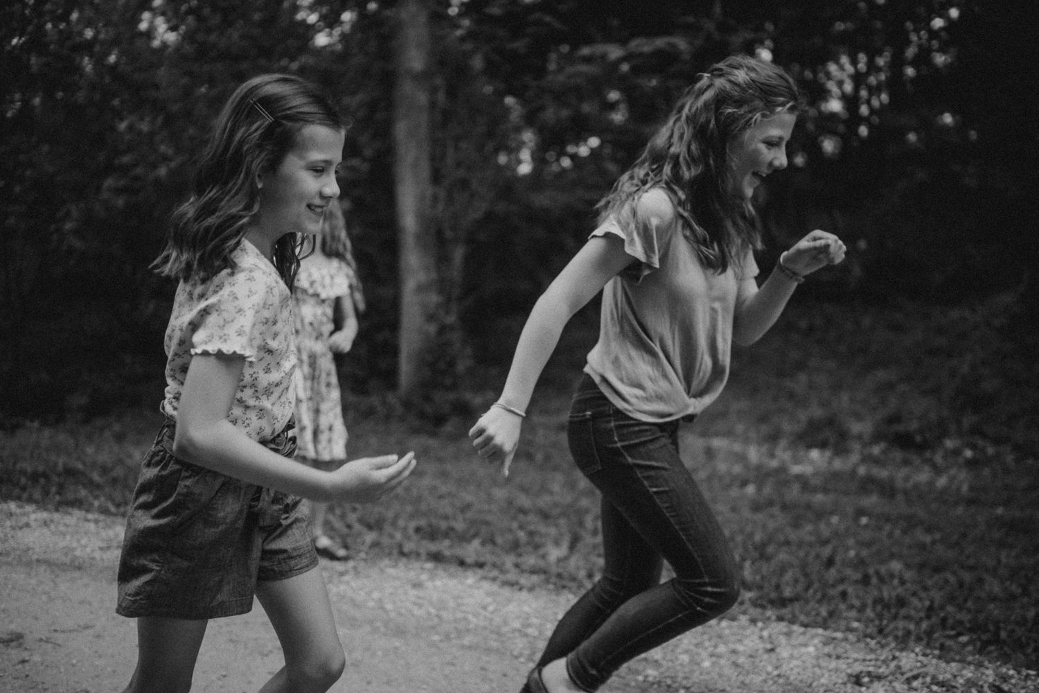 Two people run and play together in a backyard during golden hour.