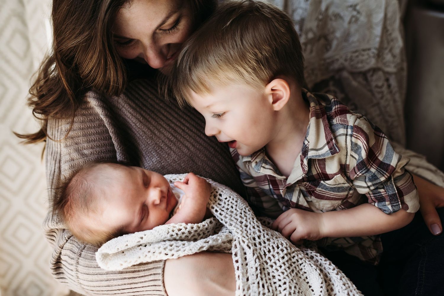 Gentle family scene with siblings bonding in cozy armchair.