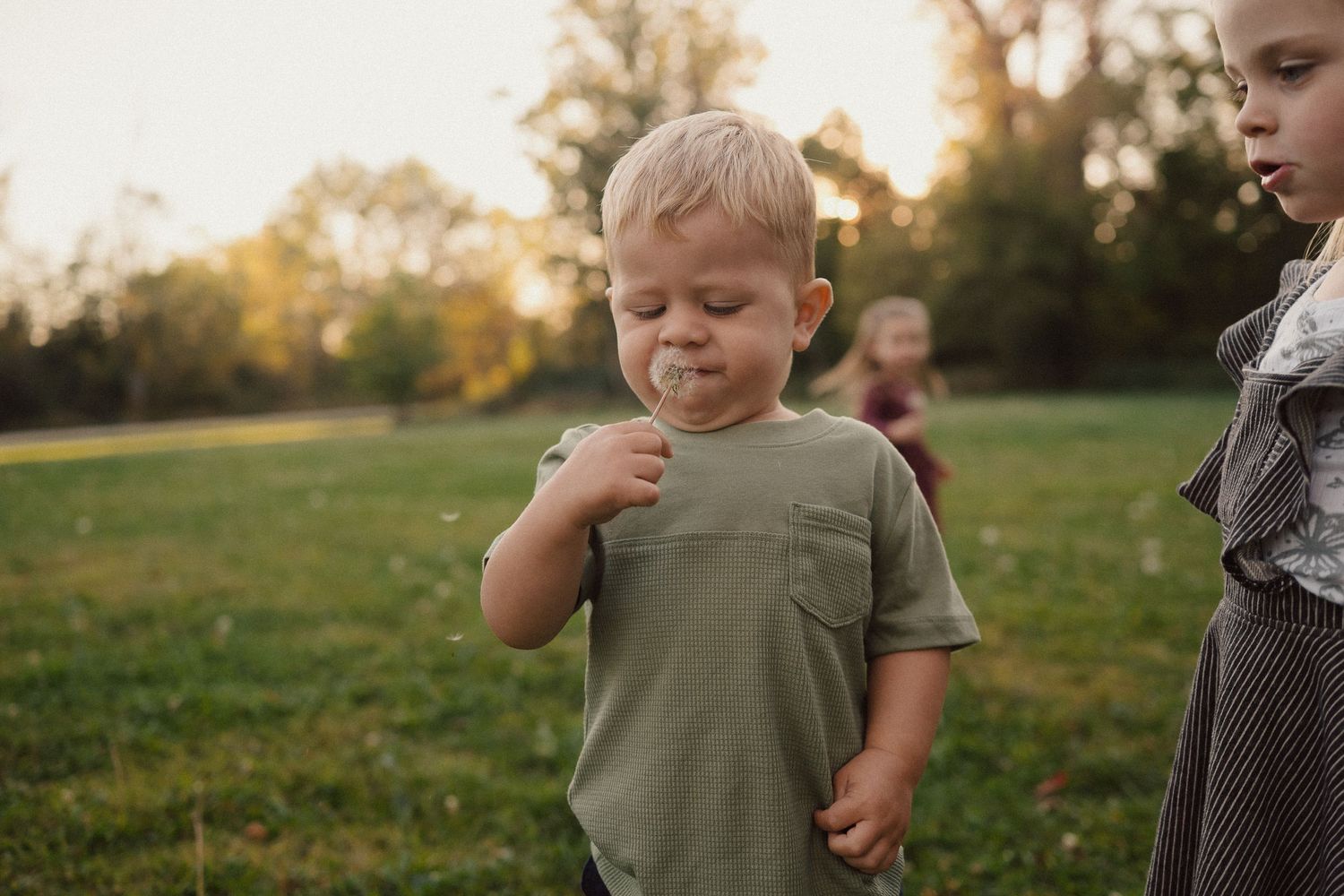 Children interact playfully in an outdoor setting during golden hour.