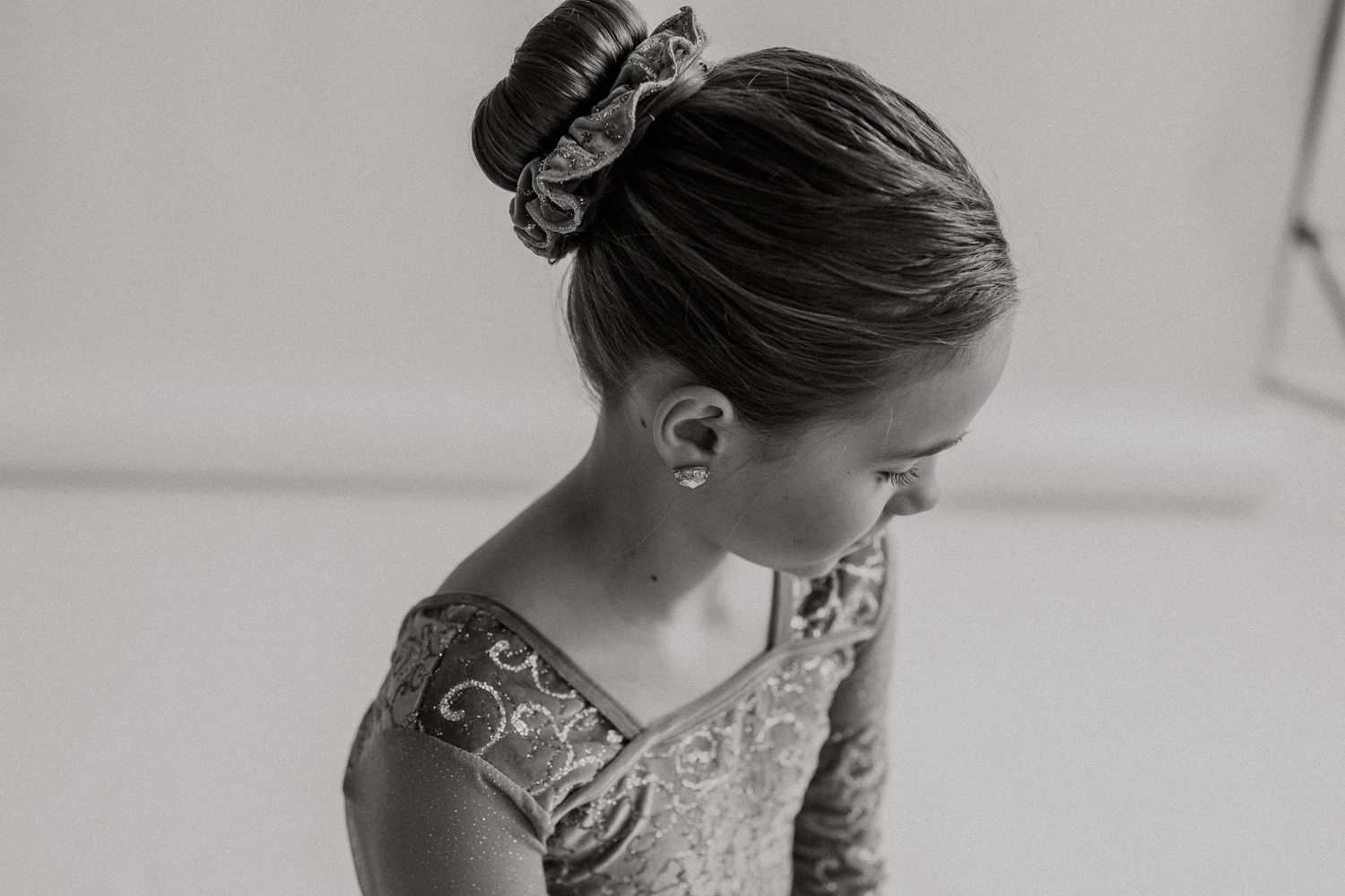 Black and white portrait of a ballet dancer with hair in a neat bun.