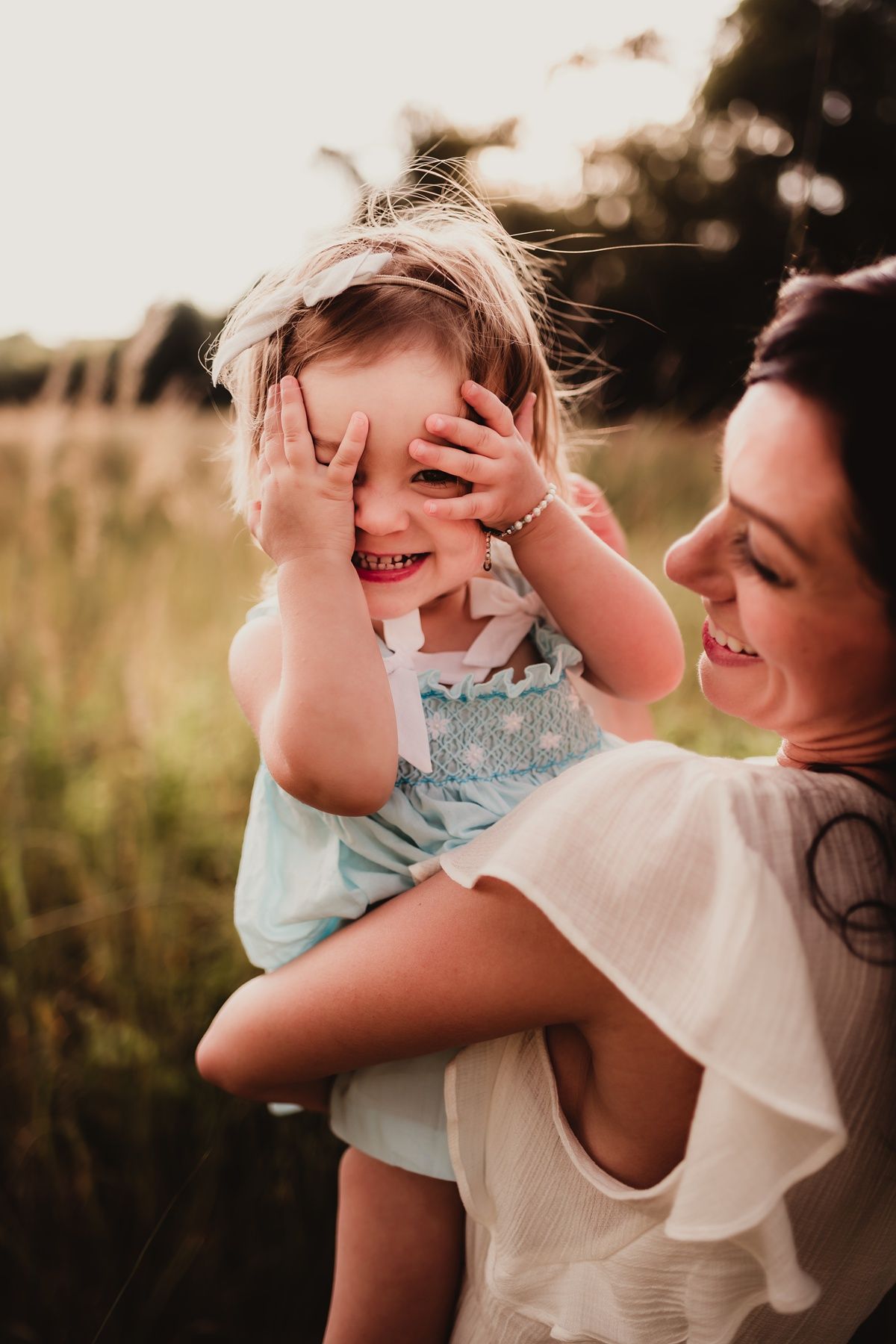 Candid moment of joy and laughter between parent and child outdoors.