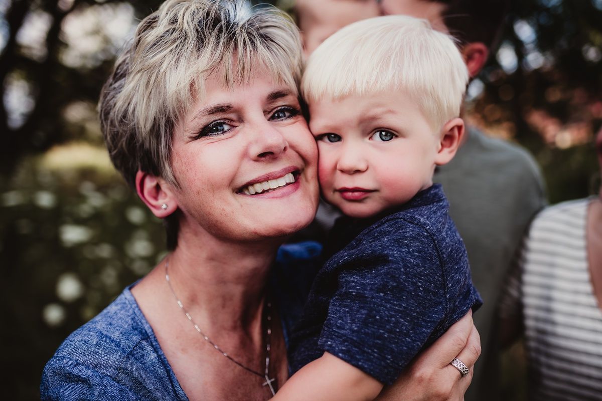 A tender moment captured between a child in a navy sweater and an adult in blue outdoors.