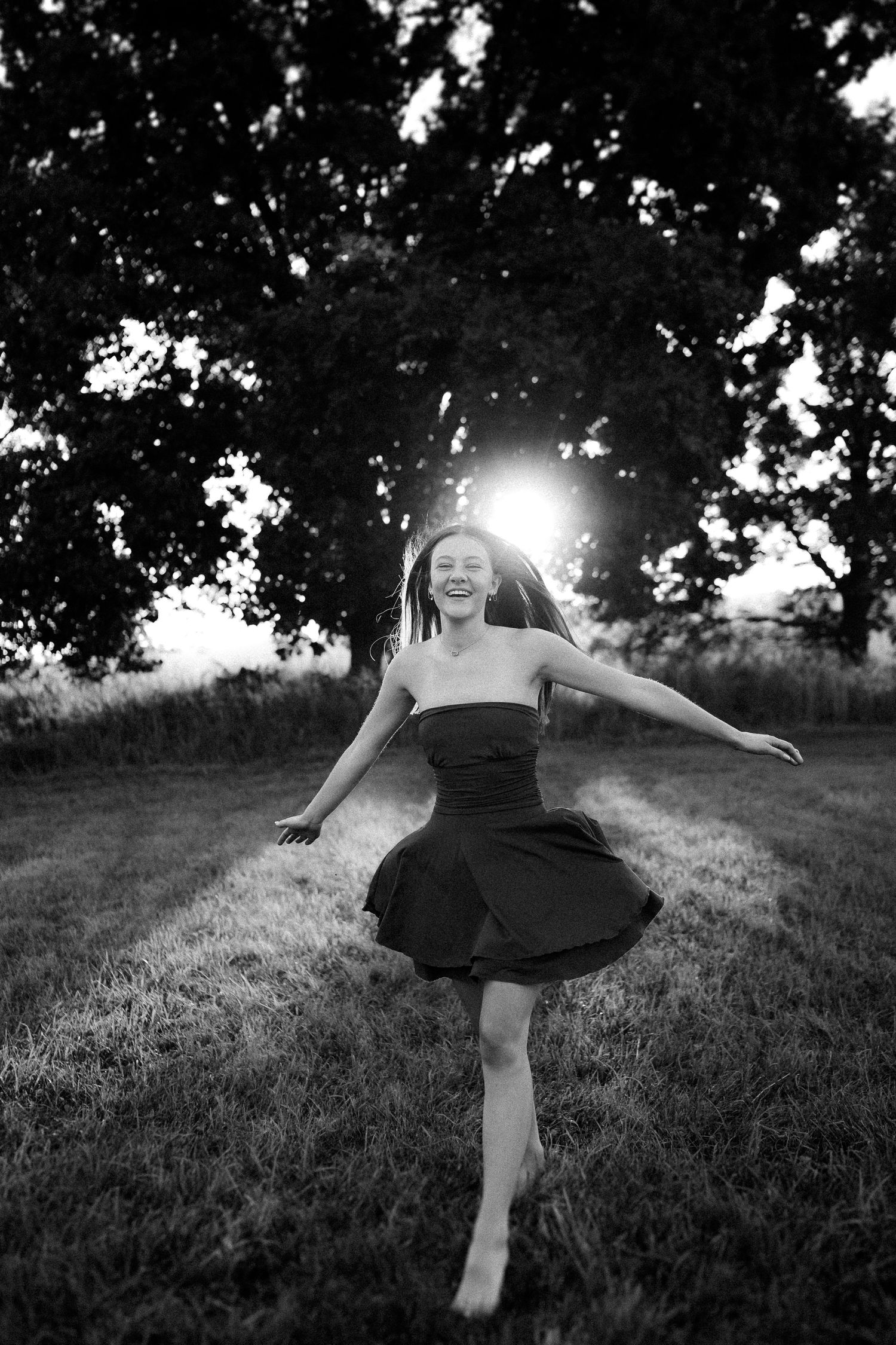 A black and white sequence showing graceful dance movements on a grassy hillside at sunset.