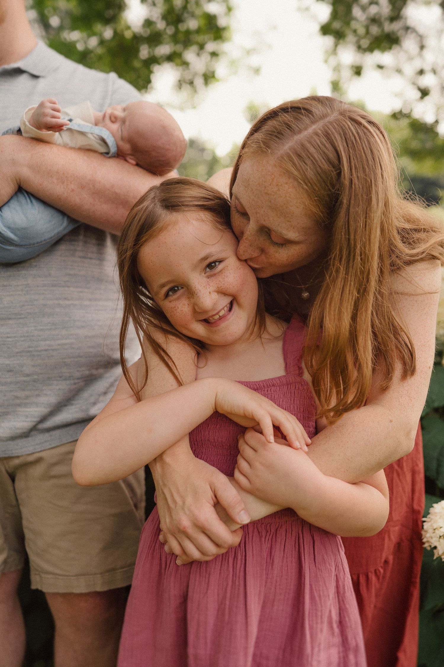 A joyful embrace captured in warm evening light with hydrangea bushes in the background.