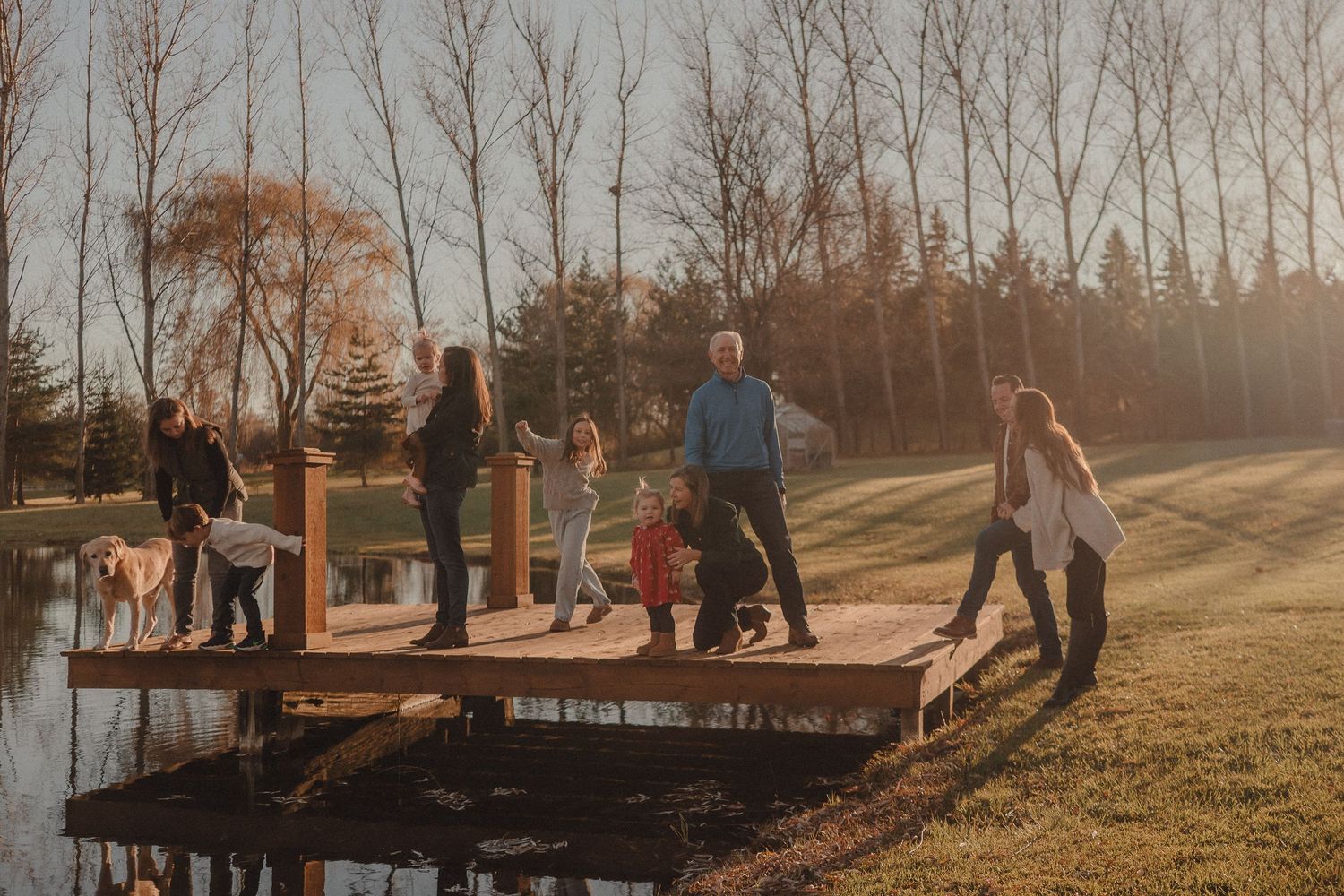 People walking together on grass path during sunset with long shadows.