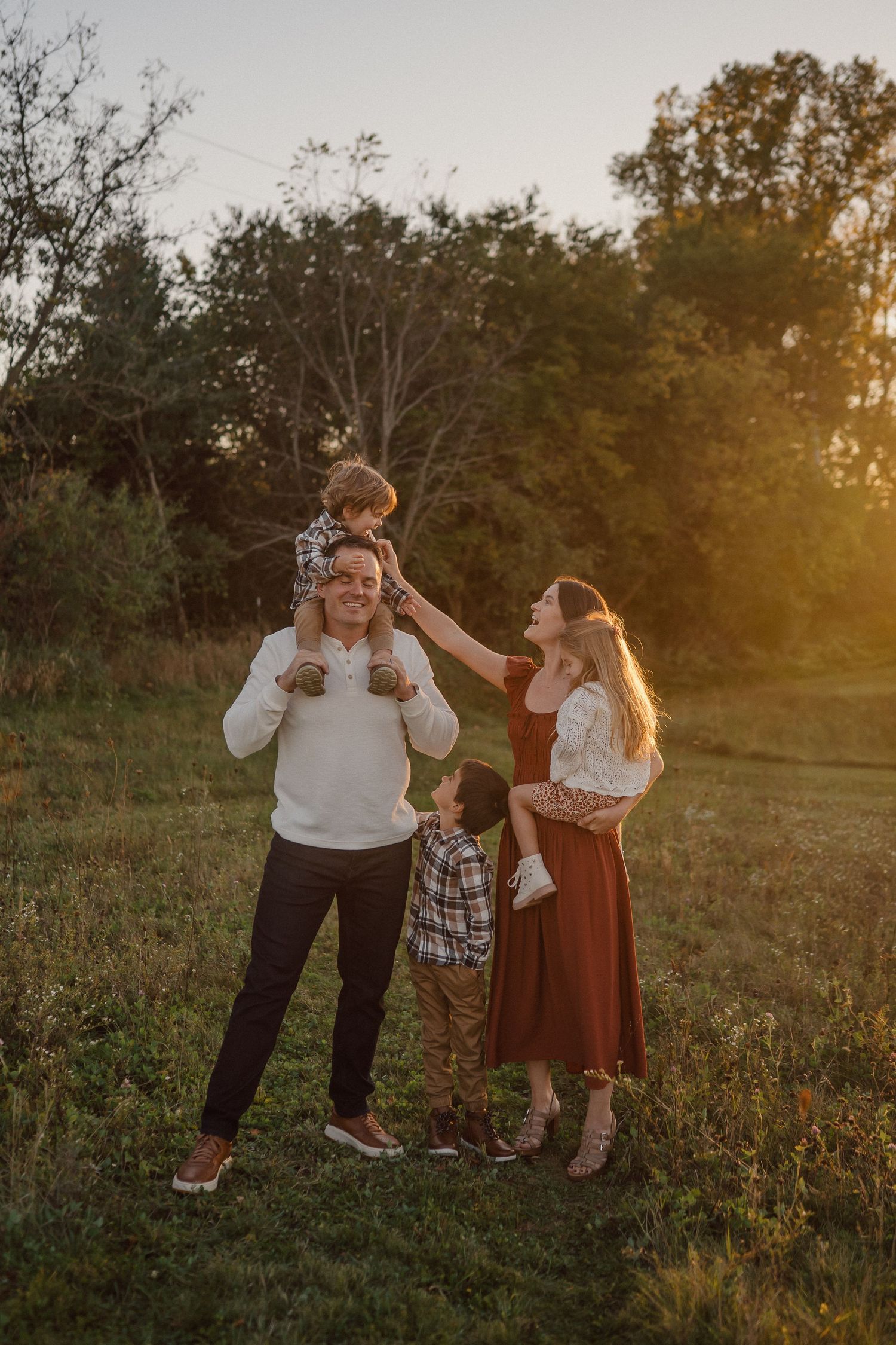Family members share joyful moments together in a sunlit field.