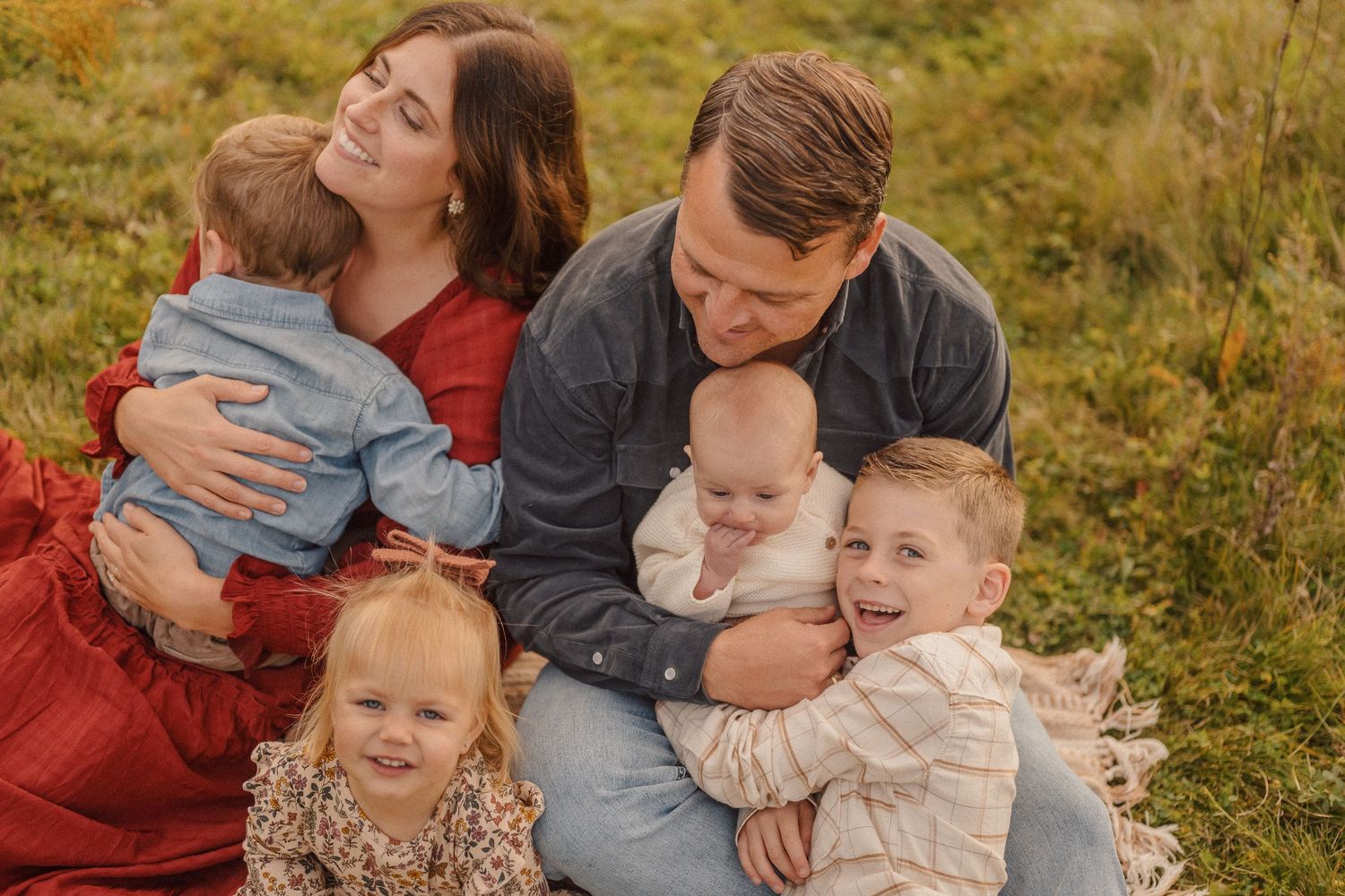 Candid family moment captured during outdoor photo session in fall setting.