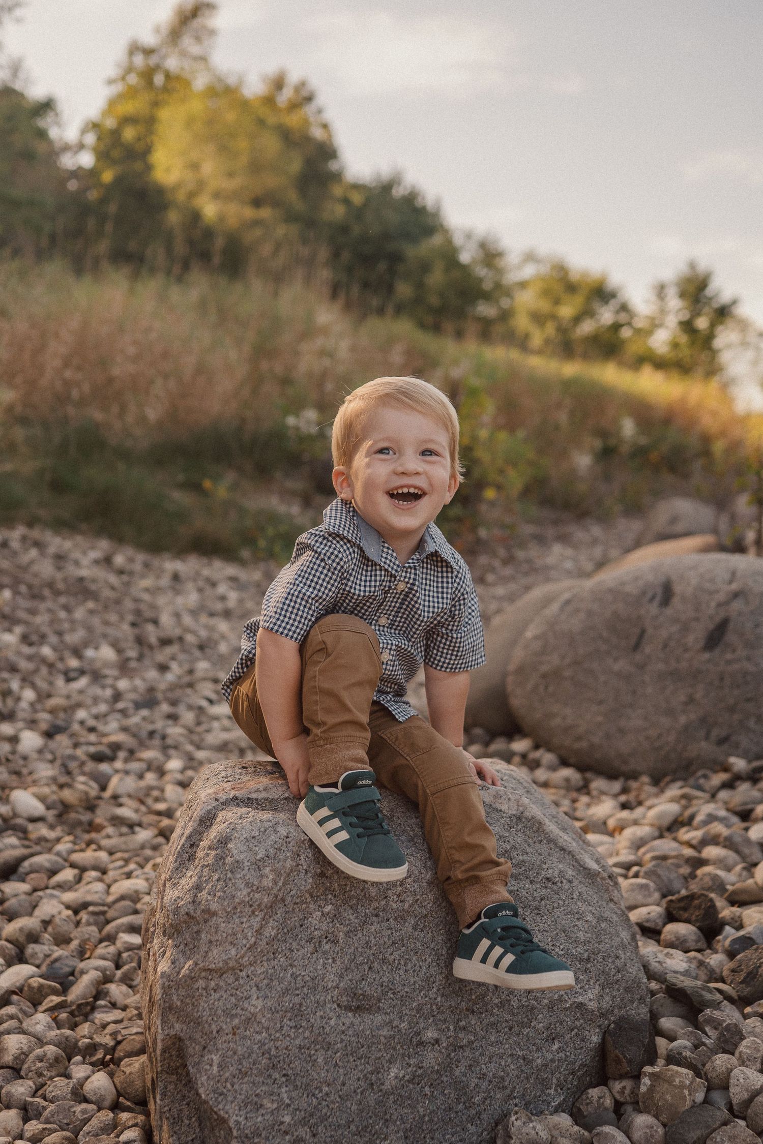 A sequence of photos showing a young child sitting and playing on large rocks in a natural outdoor setting at sunset.
