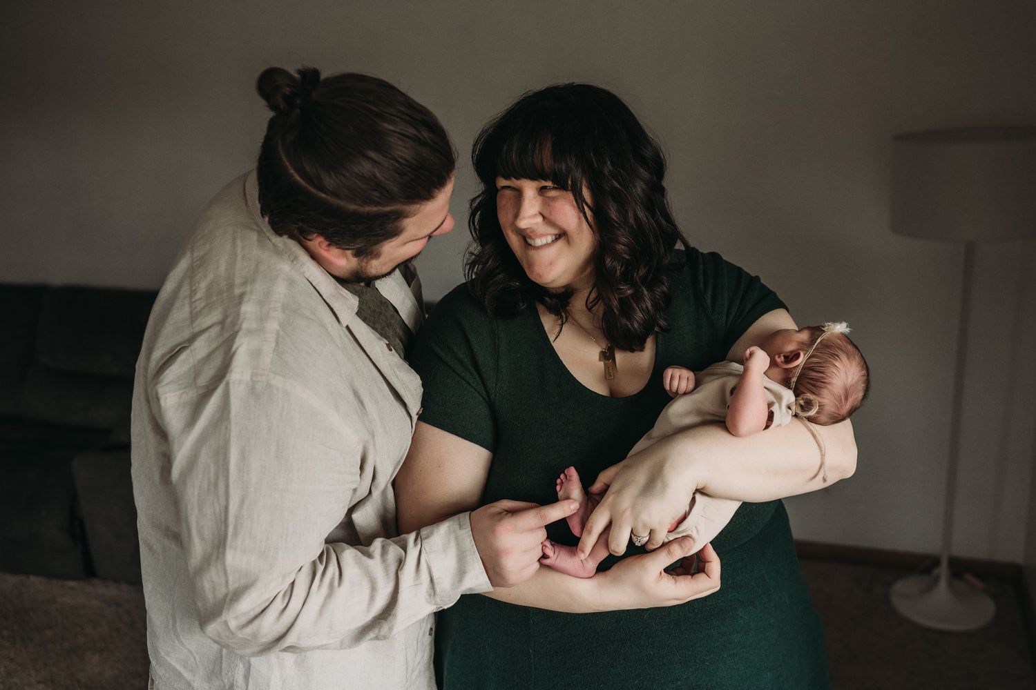 Joyful moment with newborn baby during indoor lifestyle photography session.