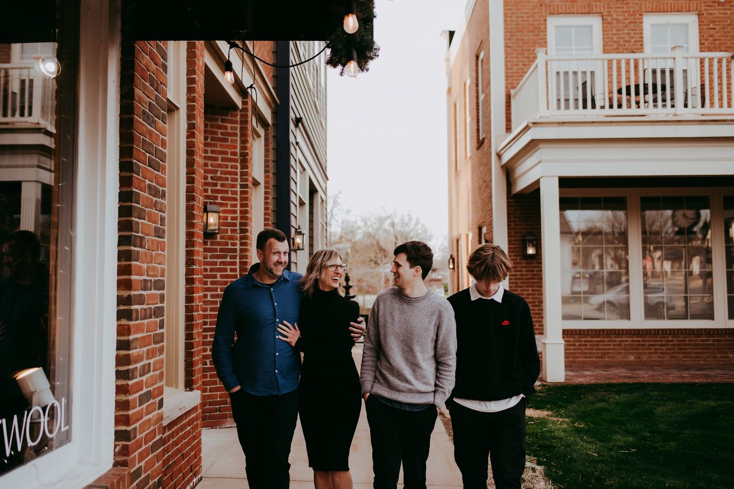 Urban lifestyle photo of friends walking between brick buildings.