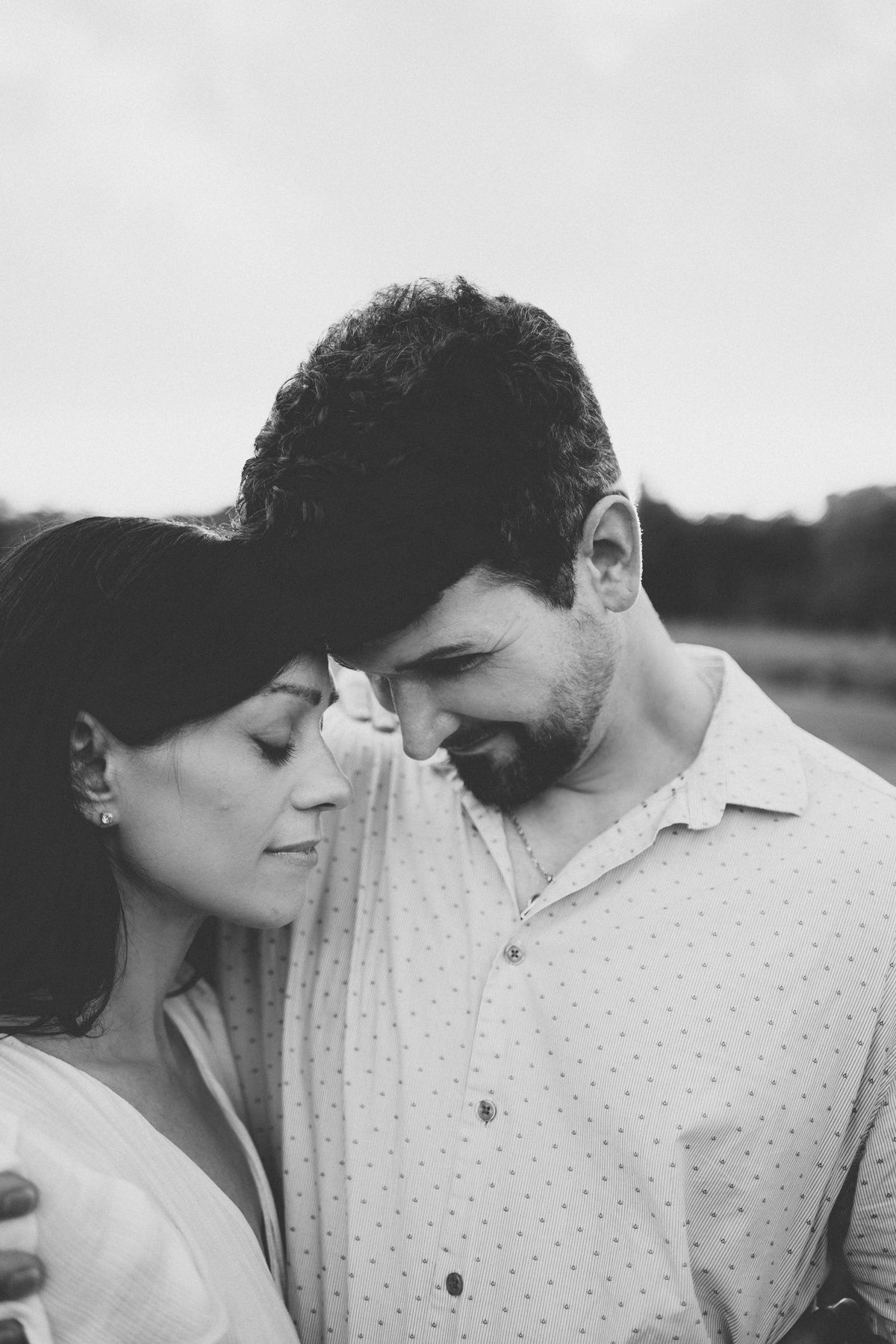 An intimate black and white portrait showing a tender moment between two people.