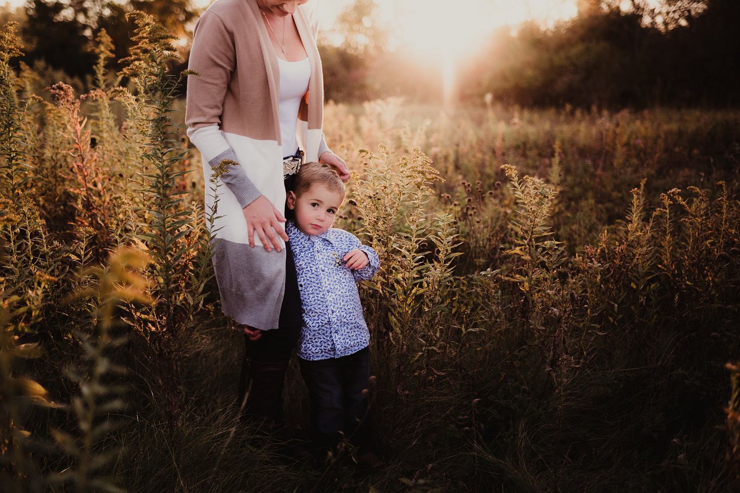 A playful moment between parent and child in a golden sunlit field.