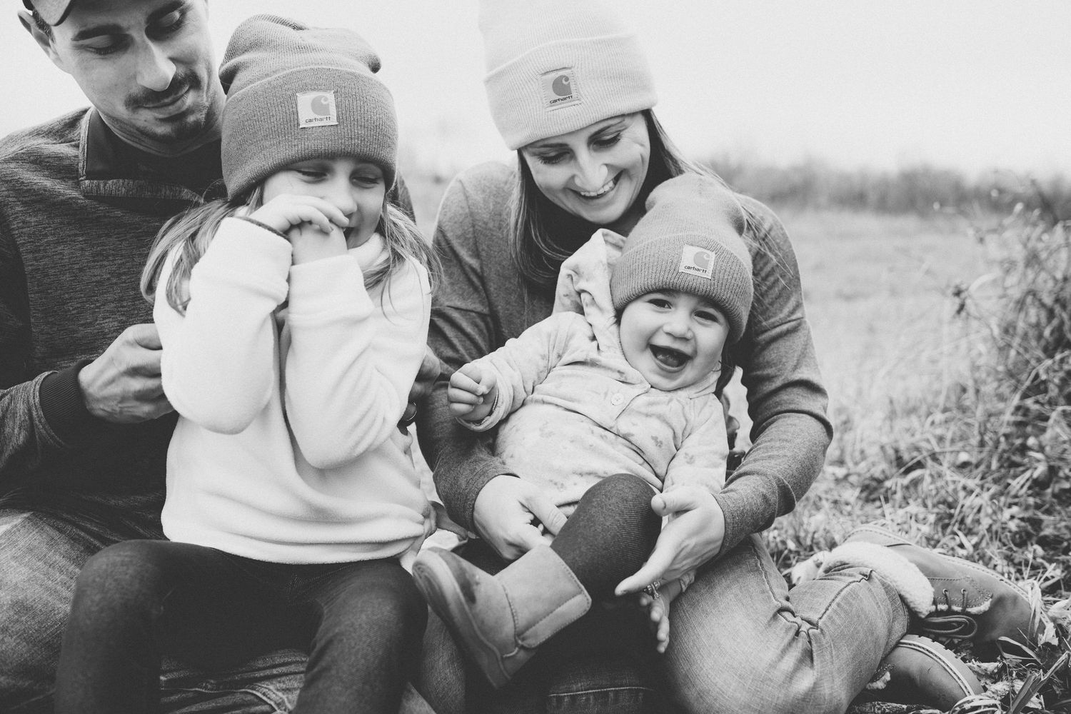 A happy family moment captured in black and white as they relax together outdoors.