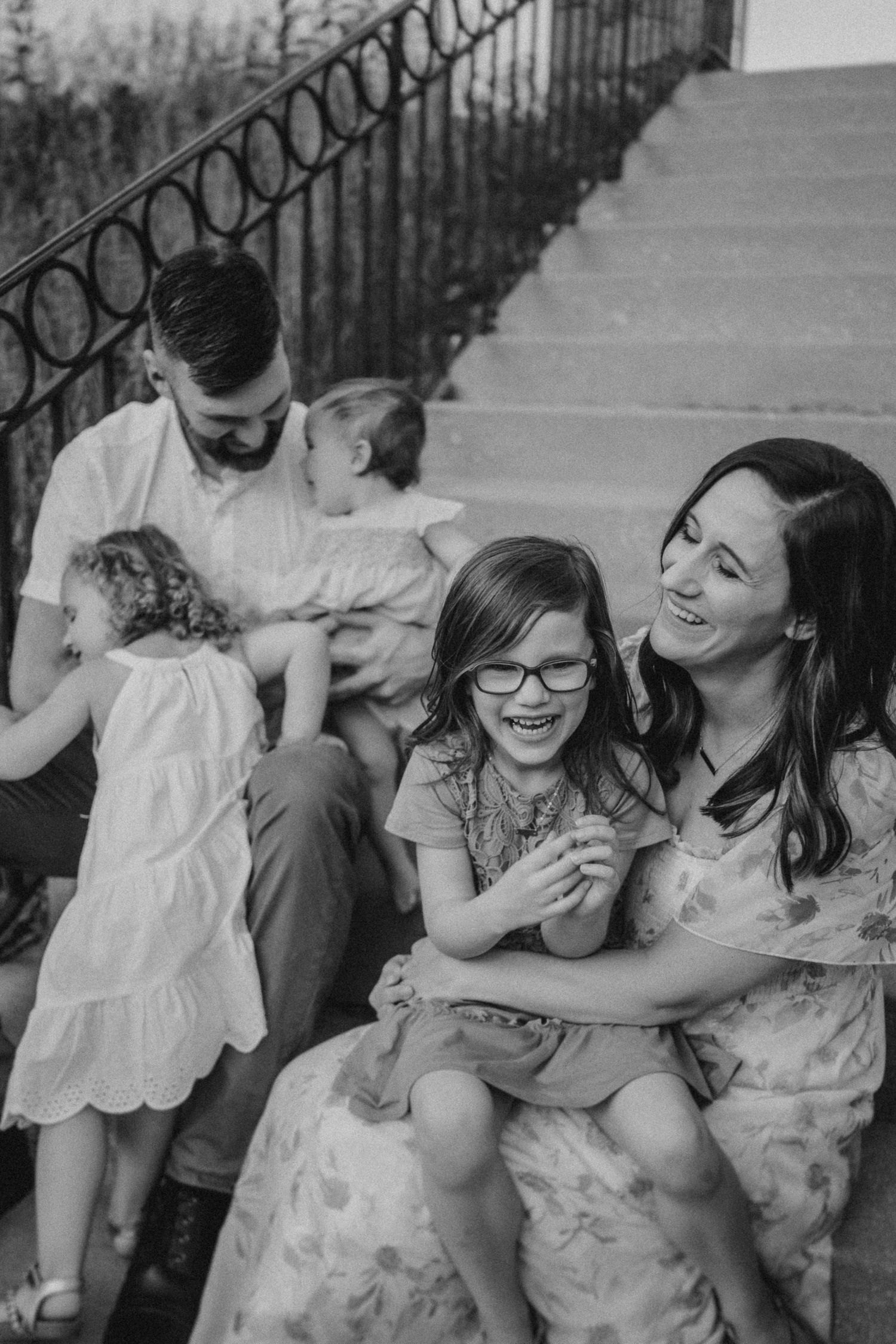 A candid black and white moment of shared laughter on outdoor stone steps.