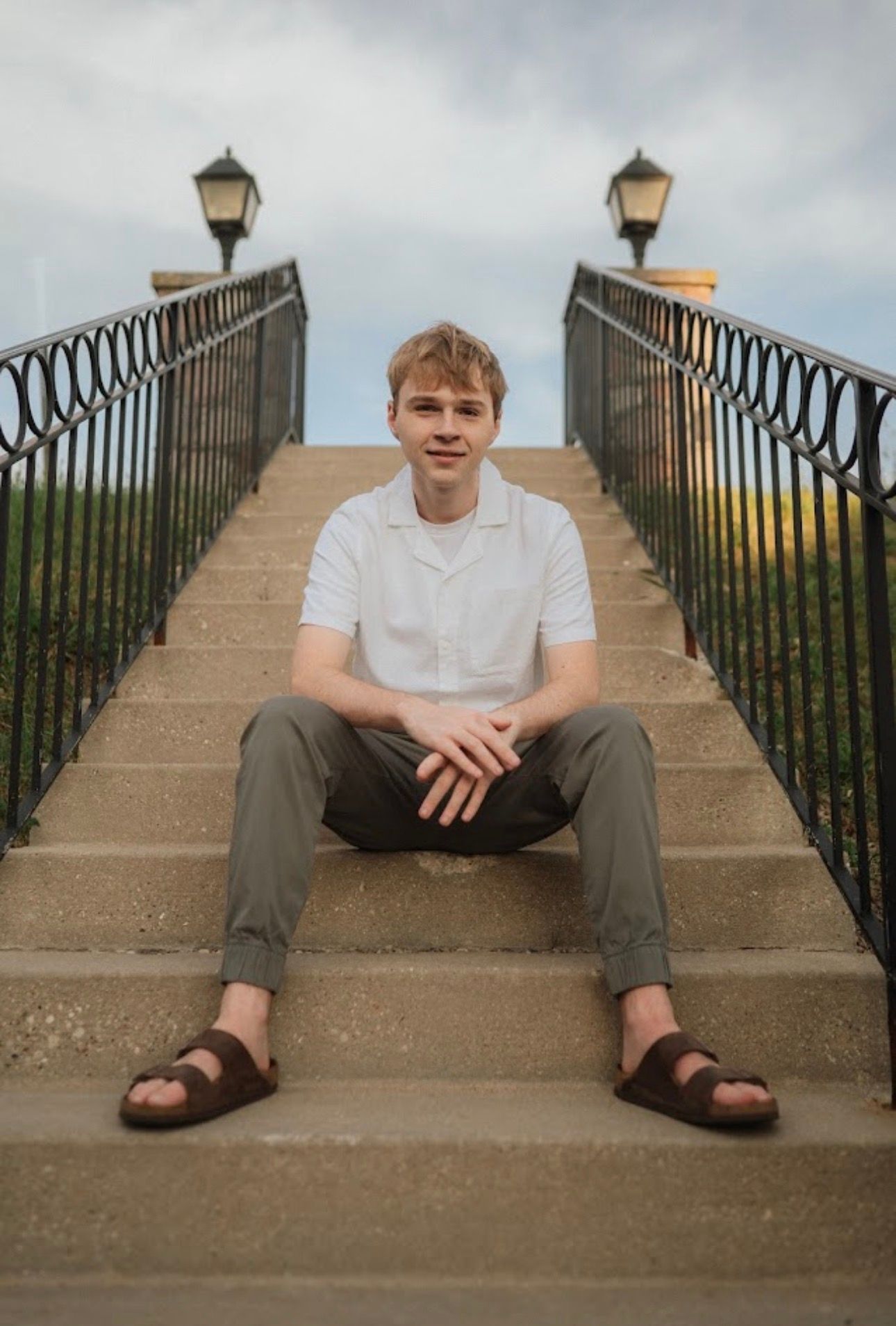 Series of casual poses on concrete steps with iron railings and lamp posts.