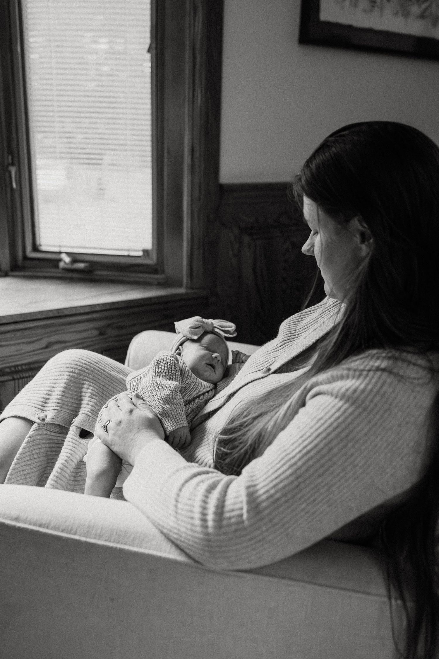 A tender black and white photograph showing a quiet moment of rest by a window.