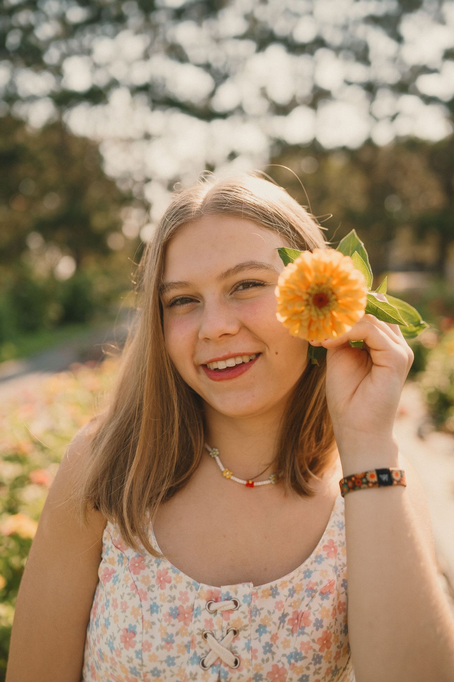 Summer portrait with sunflower against bokeh background in warm evening light.