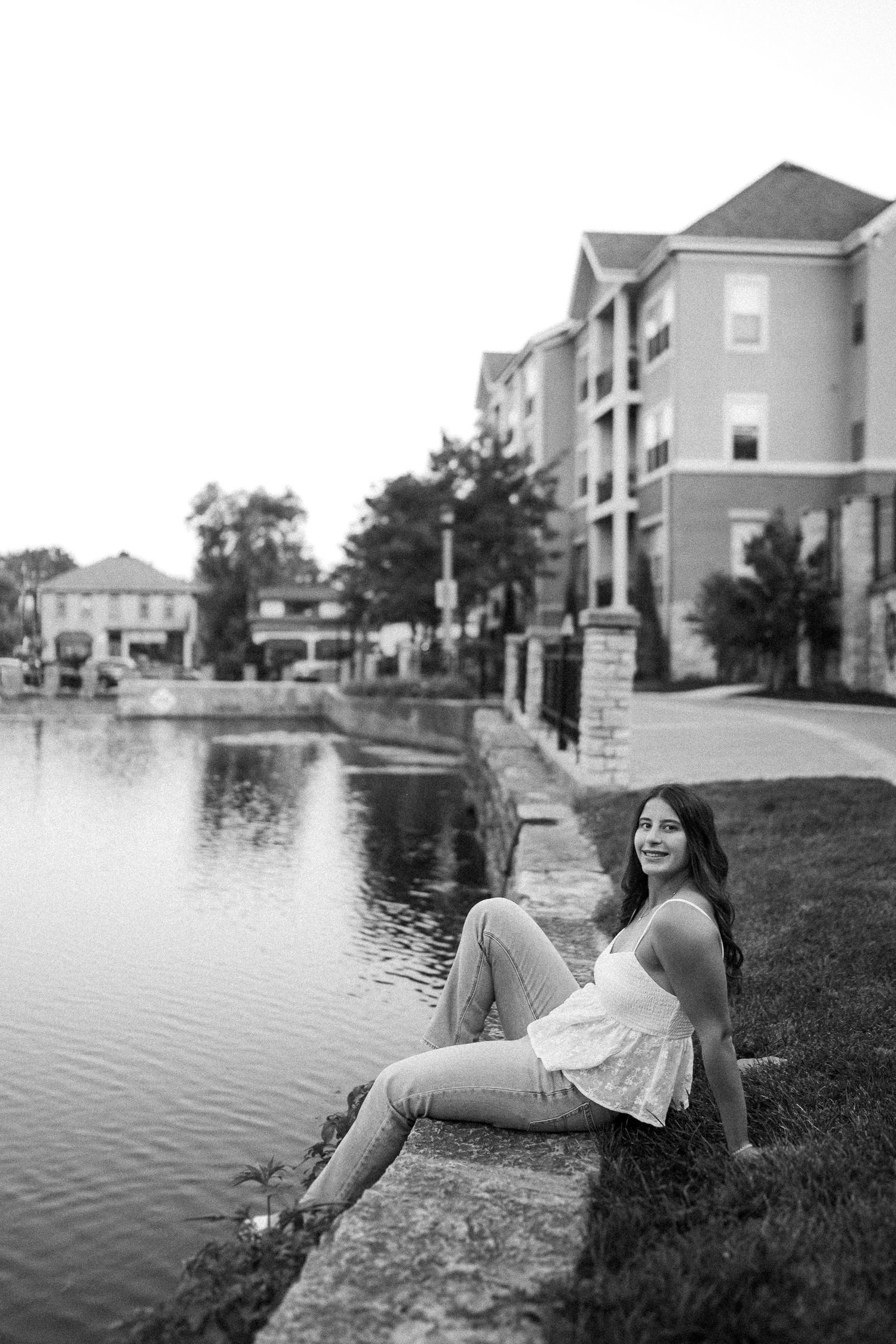 Black and white photography series by a lakeside with suburban homes in the background.