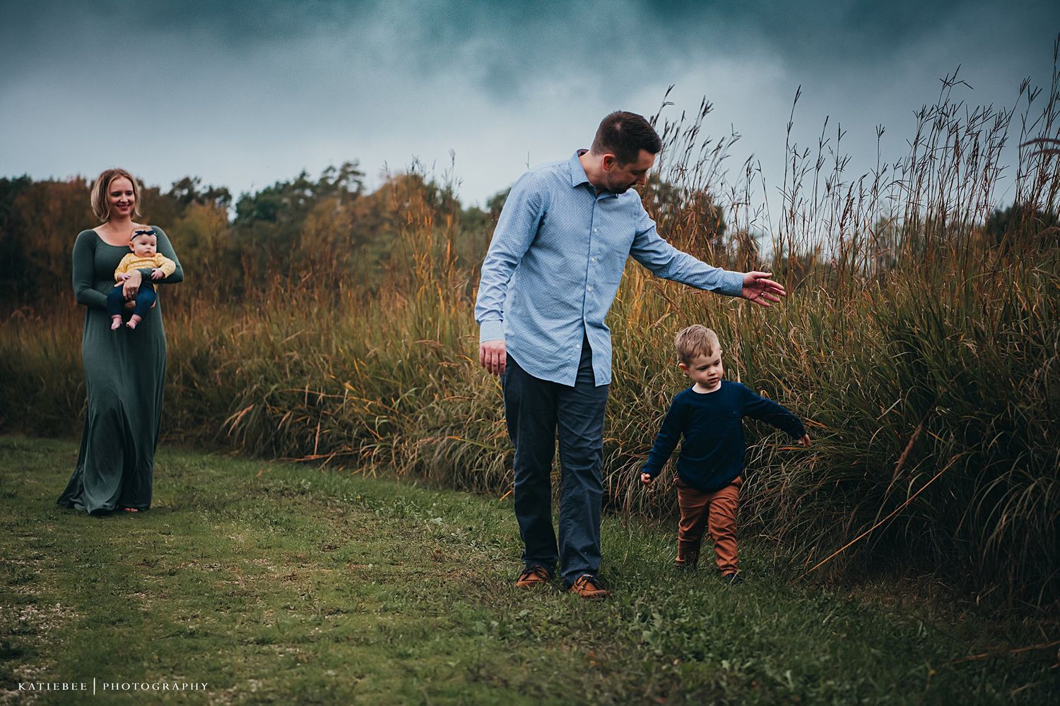 A candid family moment playing and running through tall grass at sunset.