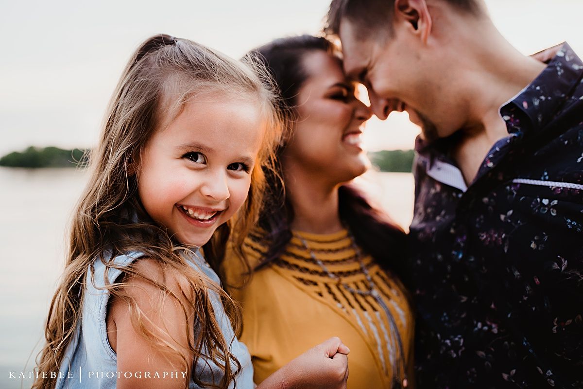 Three people sharing an intimate moment of joy and laughter outdoors.