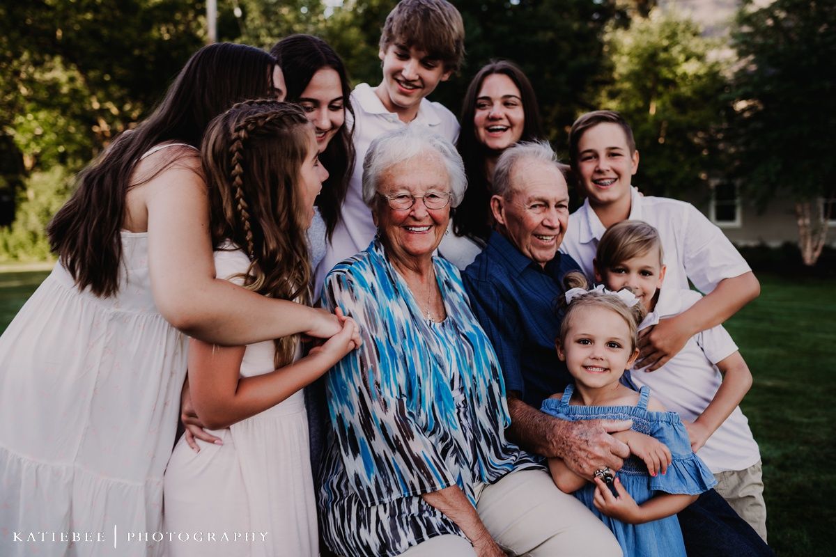 A joyful outdoor gathering with multiple generations sharing genuine laughter.