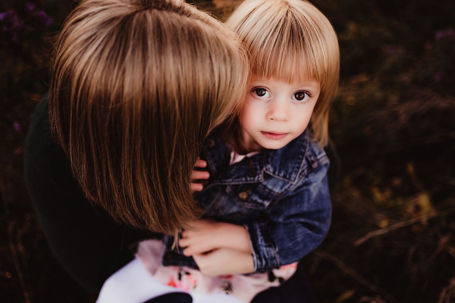 Close-up portrait of two people bonding outdoors in denim.