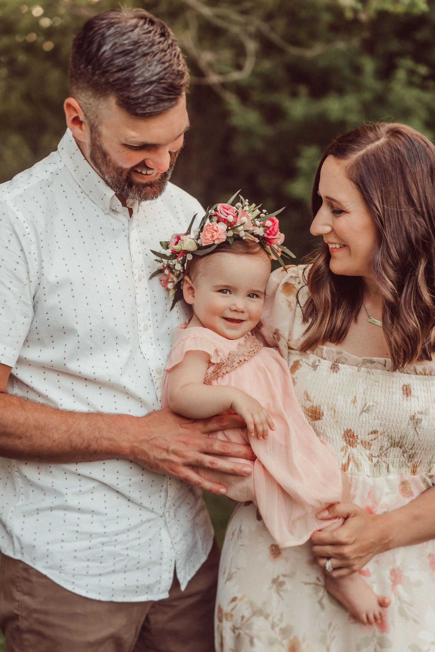 Family sharing tender moment together outdoors in summer attire.
