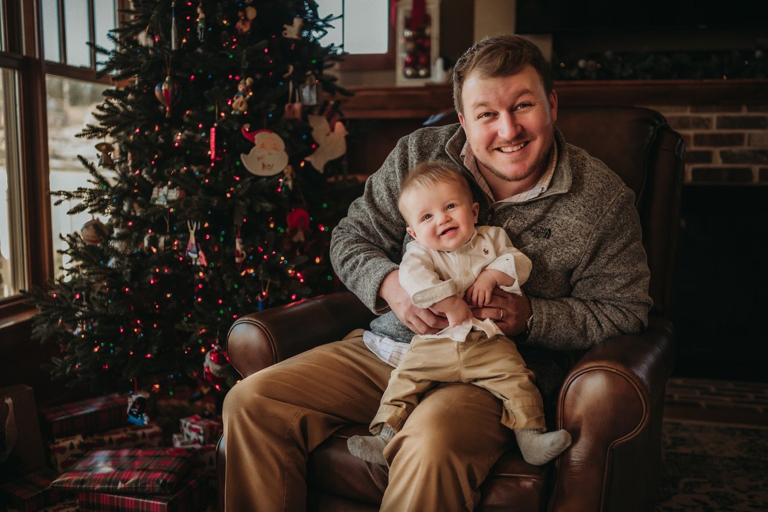 Festive holiday moment captured near decorated Christmas tree with twinkling lights.