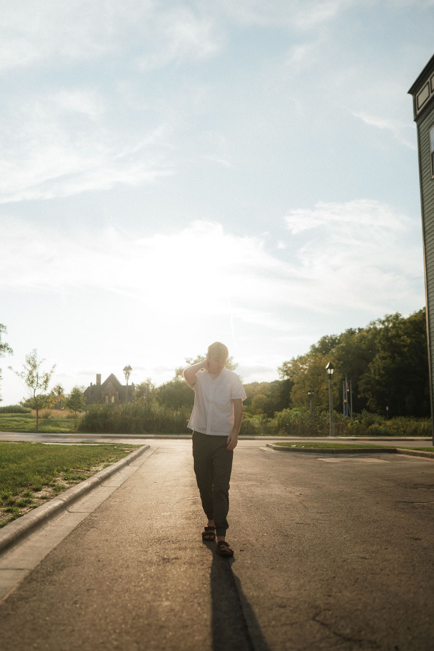 A sequence of silhouetted walking shots on a sun-drenched suburban street at golden hour.