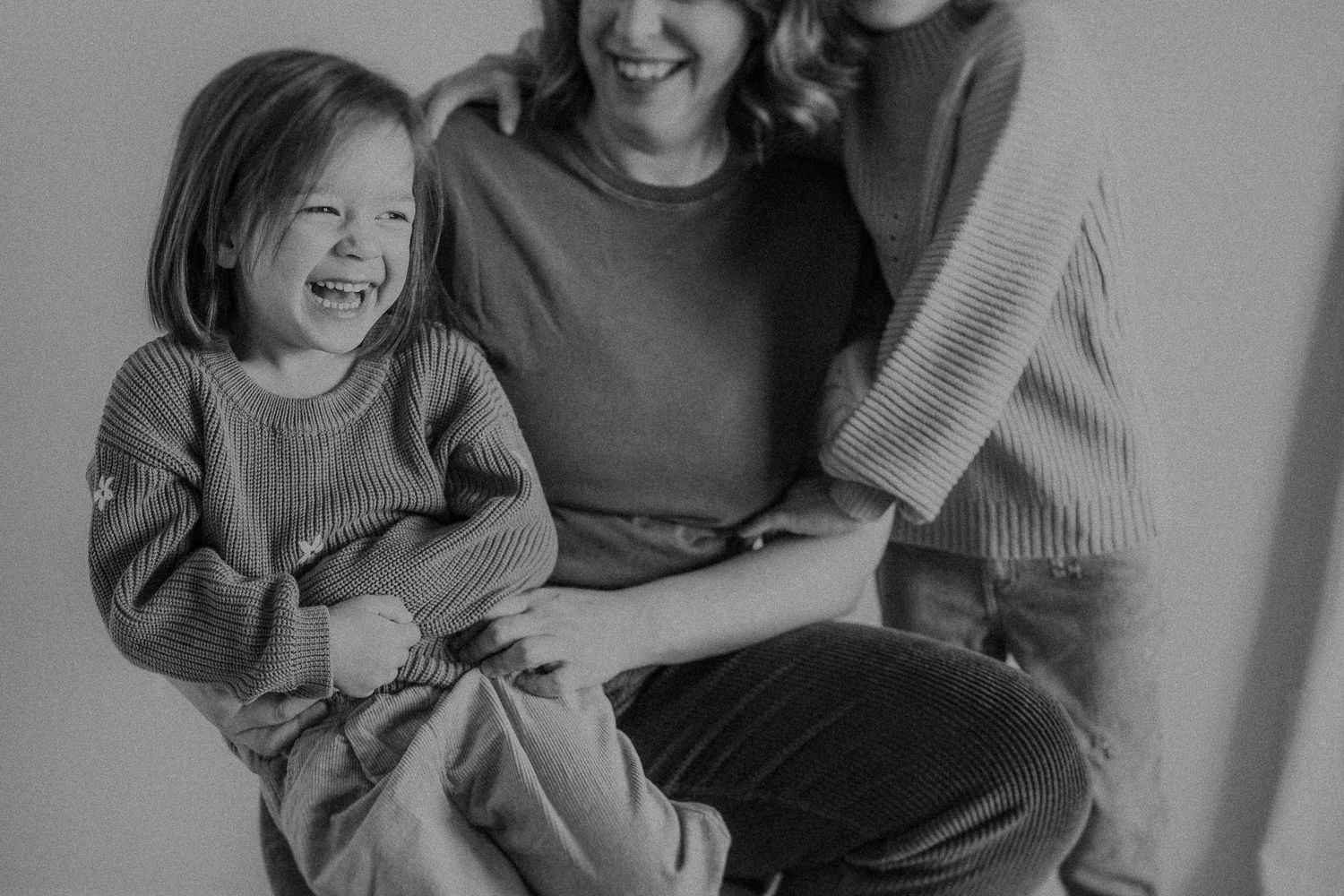 Black and white photograph capturing a moment of shared laughter and joy.