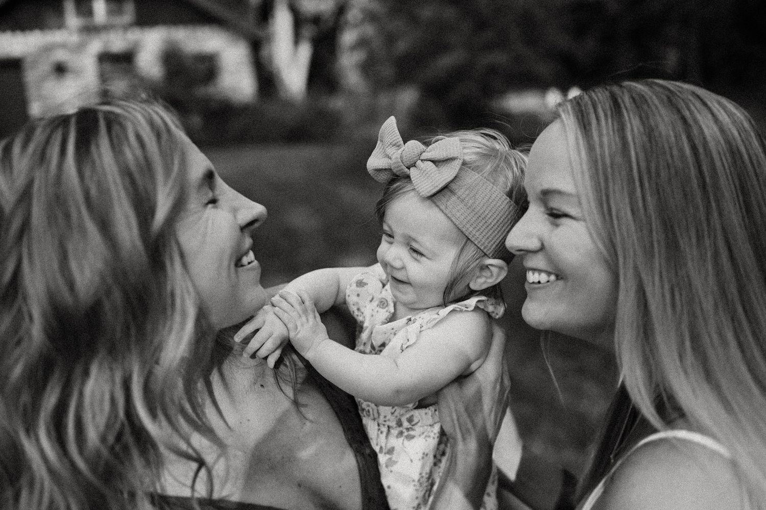 A black and white capture of shared laughter and joy in an outdoor setting.
