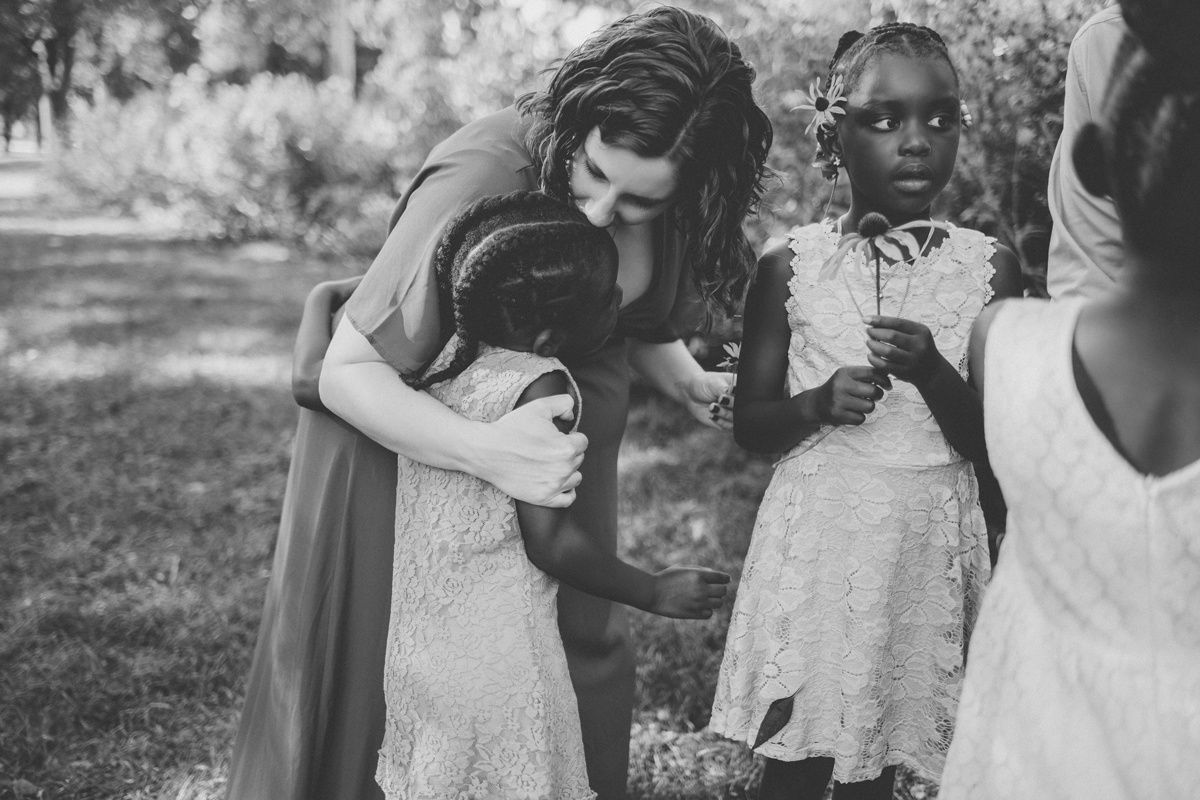 A sweet moment outdoors captured in black and white as people gather together in a garden setting.