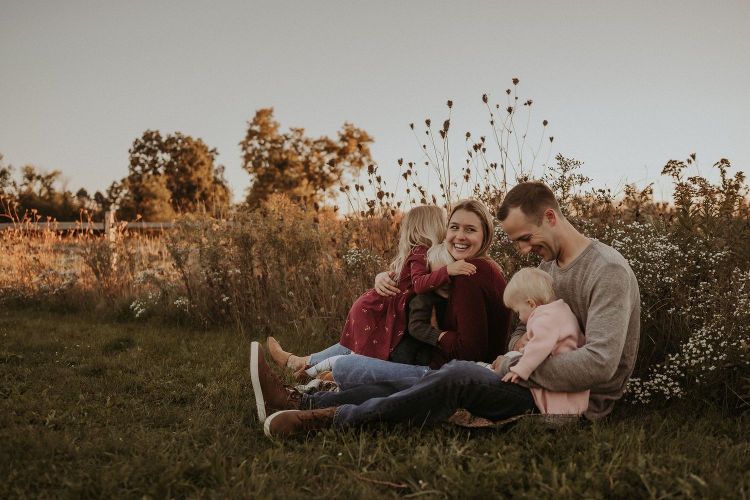 Intimate family moment captured during sunset photoshoot in natural outdoor setting.